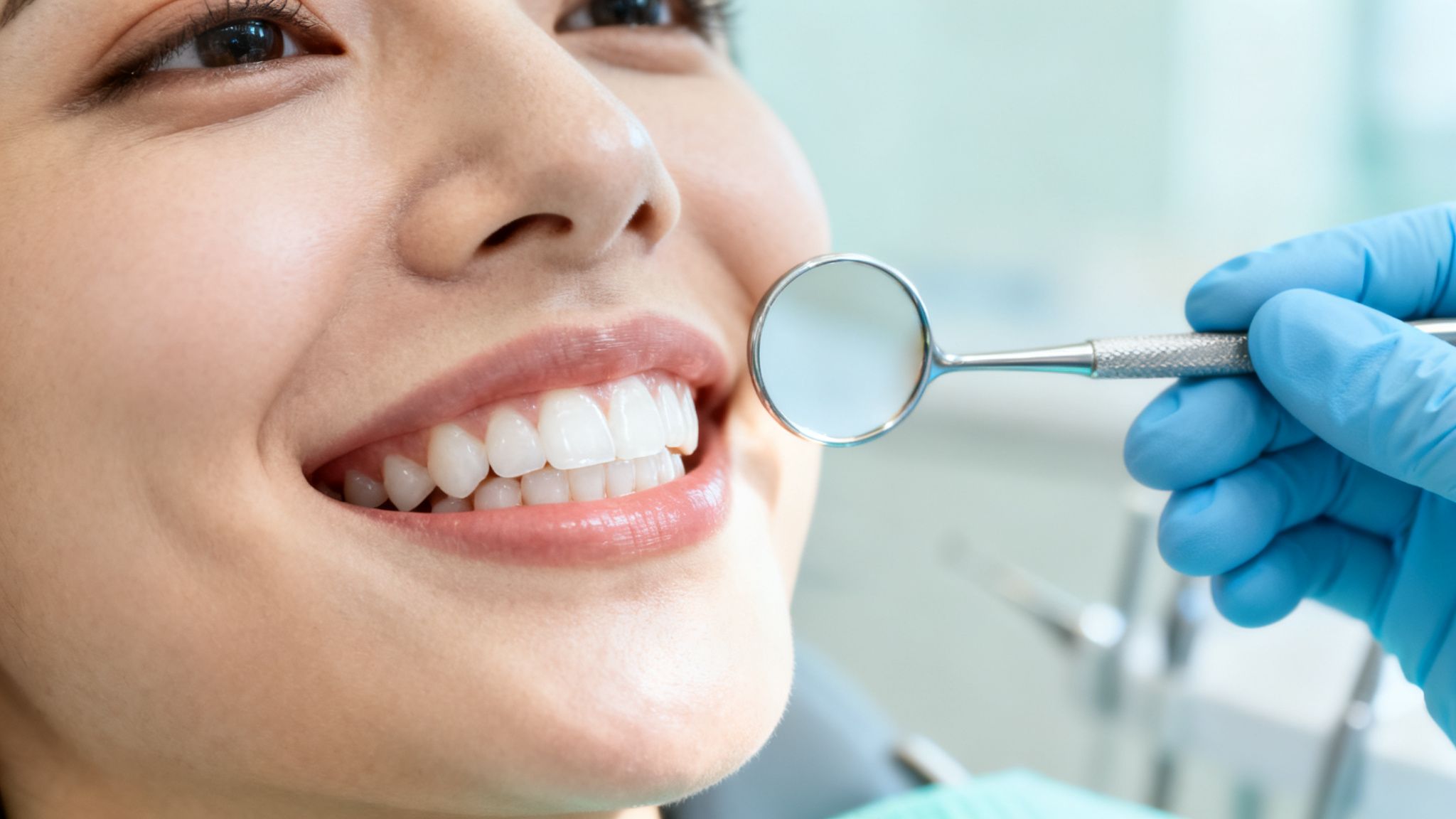 Close-up of a smiling patient with bright white teeth during a dental check-up.