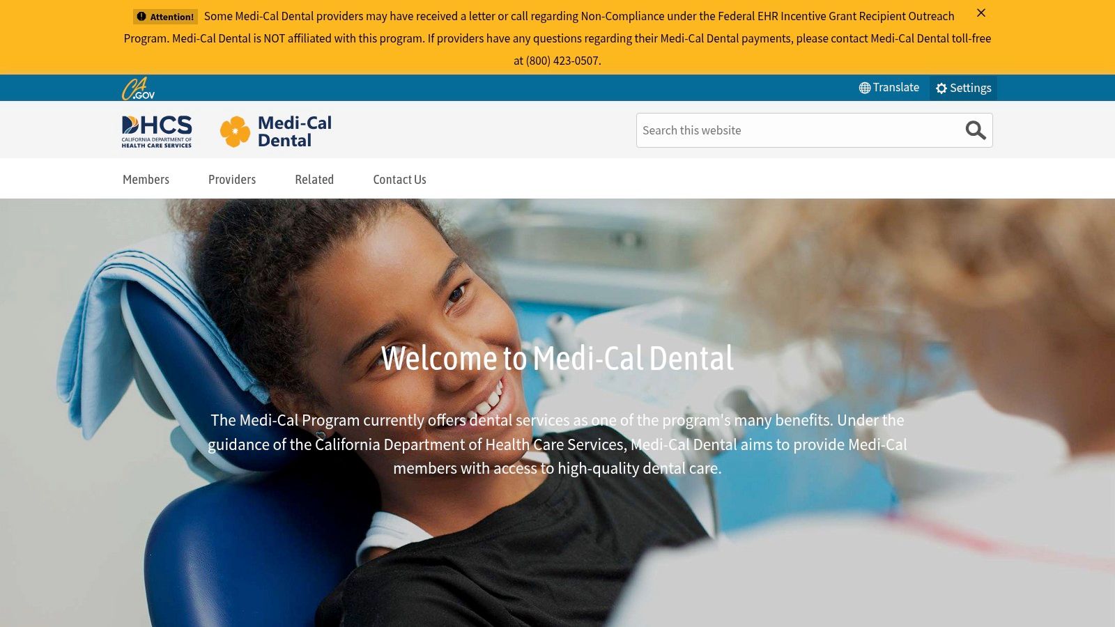A young child smiling while receiving a dental check-up, representing Denti-Cal's coverage for children.