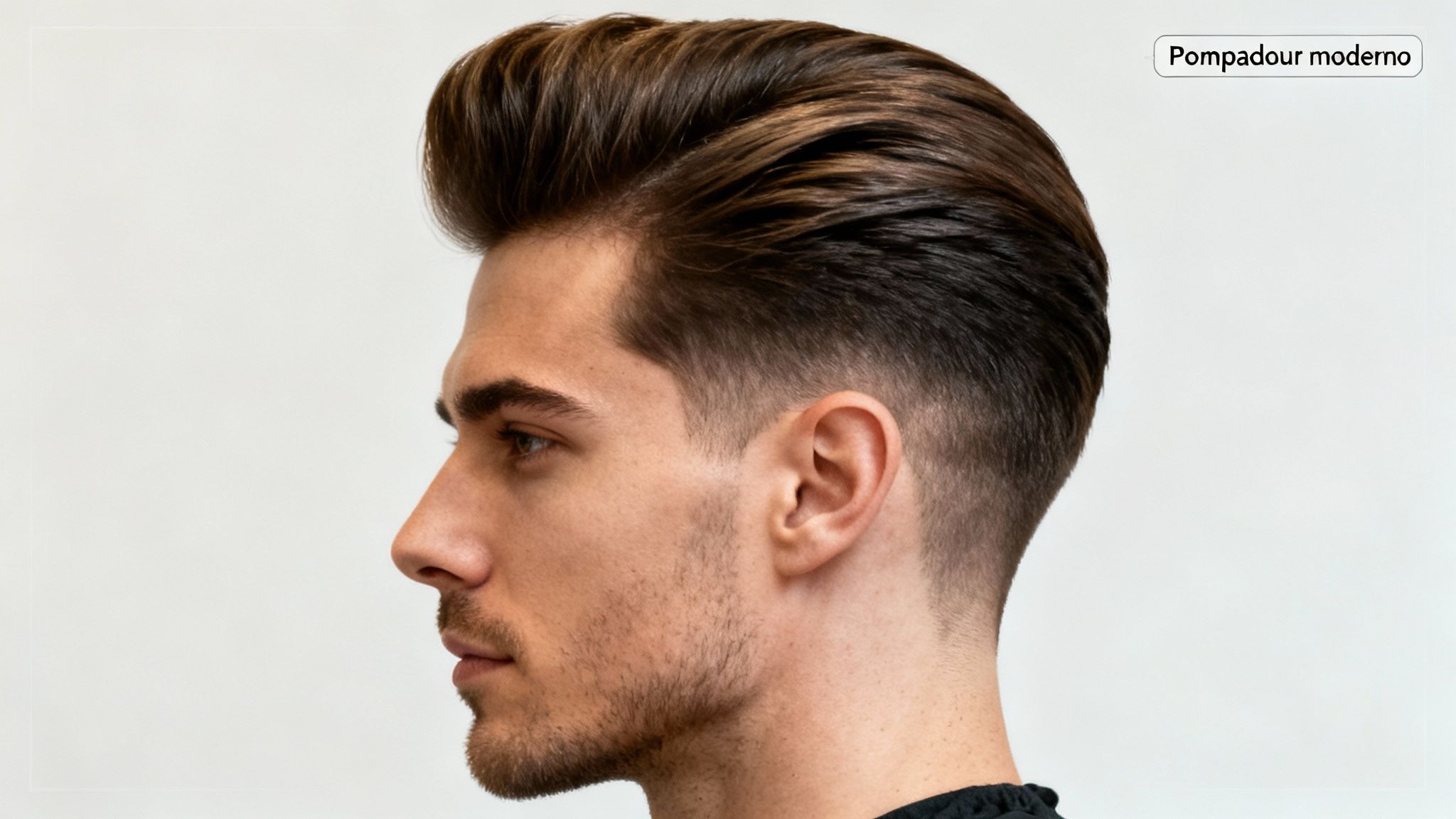 Hombre joven con un peinado pompadour moderno y degradado en los lados, vista de perfil.
