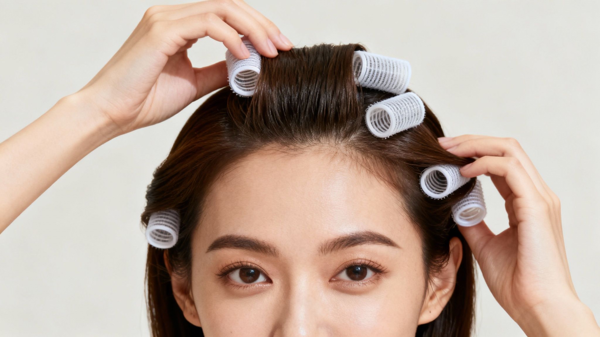 Mujer peinándose con rulos de velcro para conseguir más volumen en el pelo.