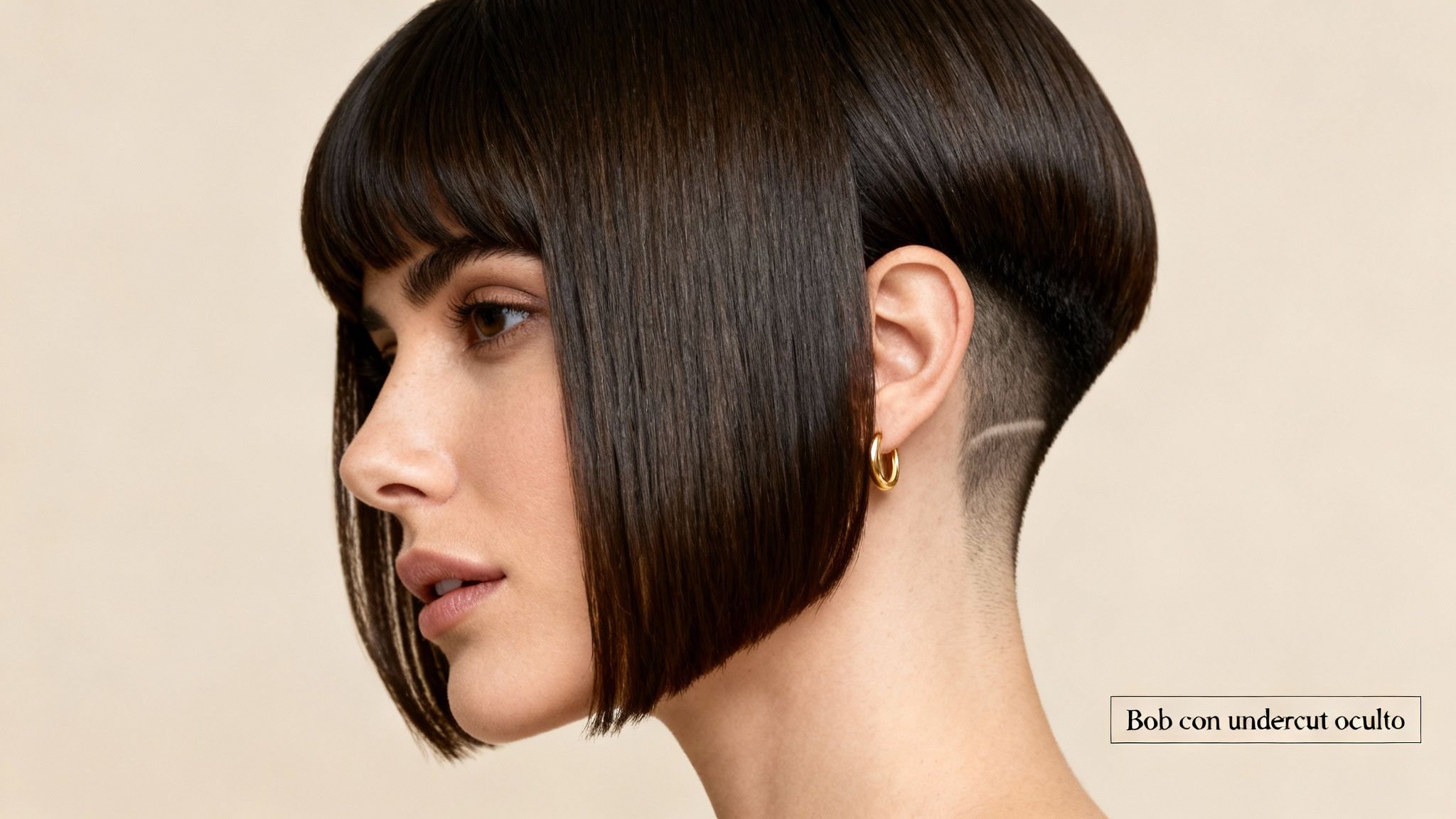 Una mujer con un elegante corte de pelo bob oscuro, que revela un undercut con un diseño afeitado.