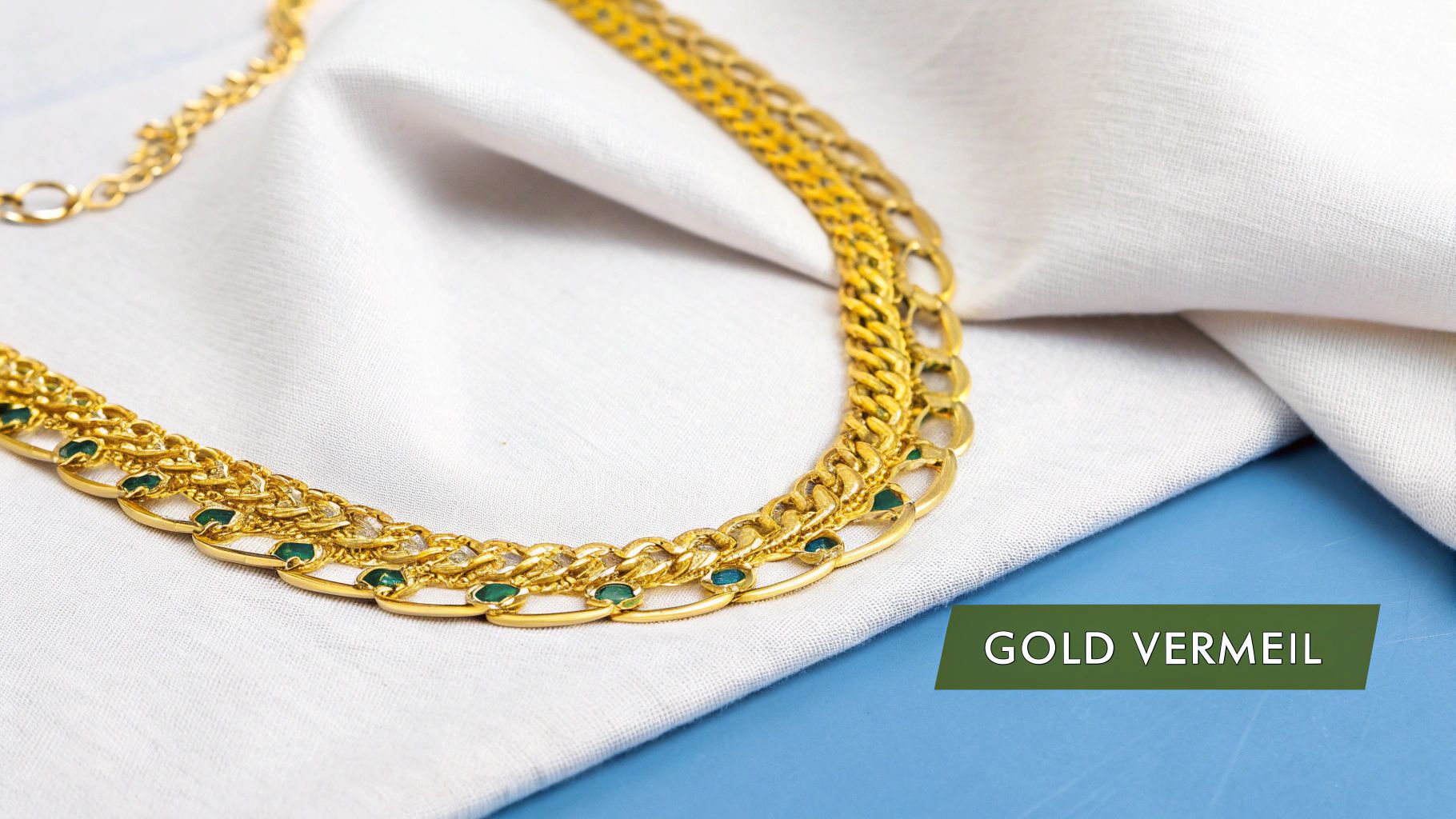A close-up of gold vermeil necklaces and rings arranged artfully.