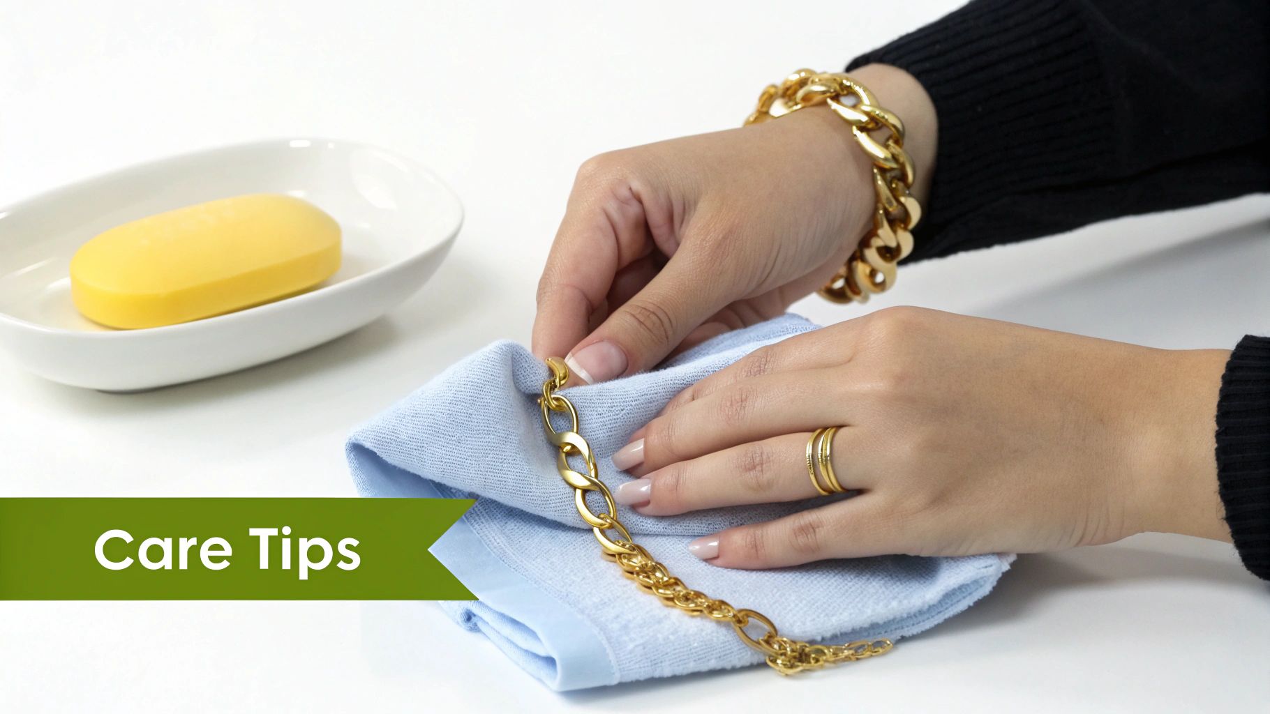 A person's hand holding a delicate 14k gold plated necklace against a soft, neutral background.