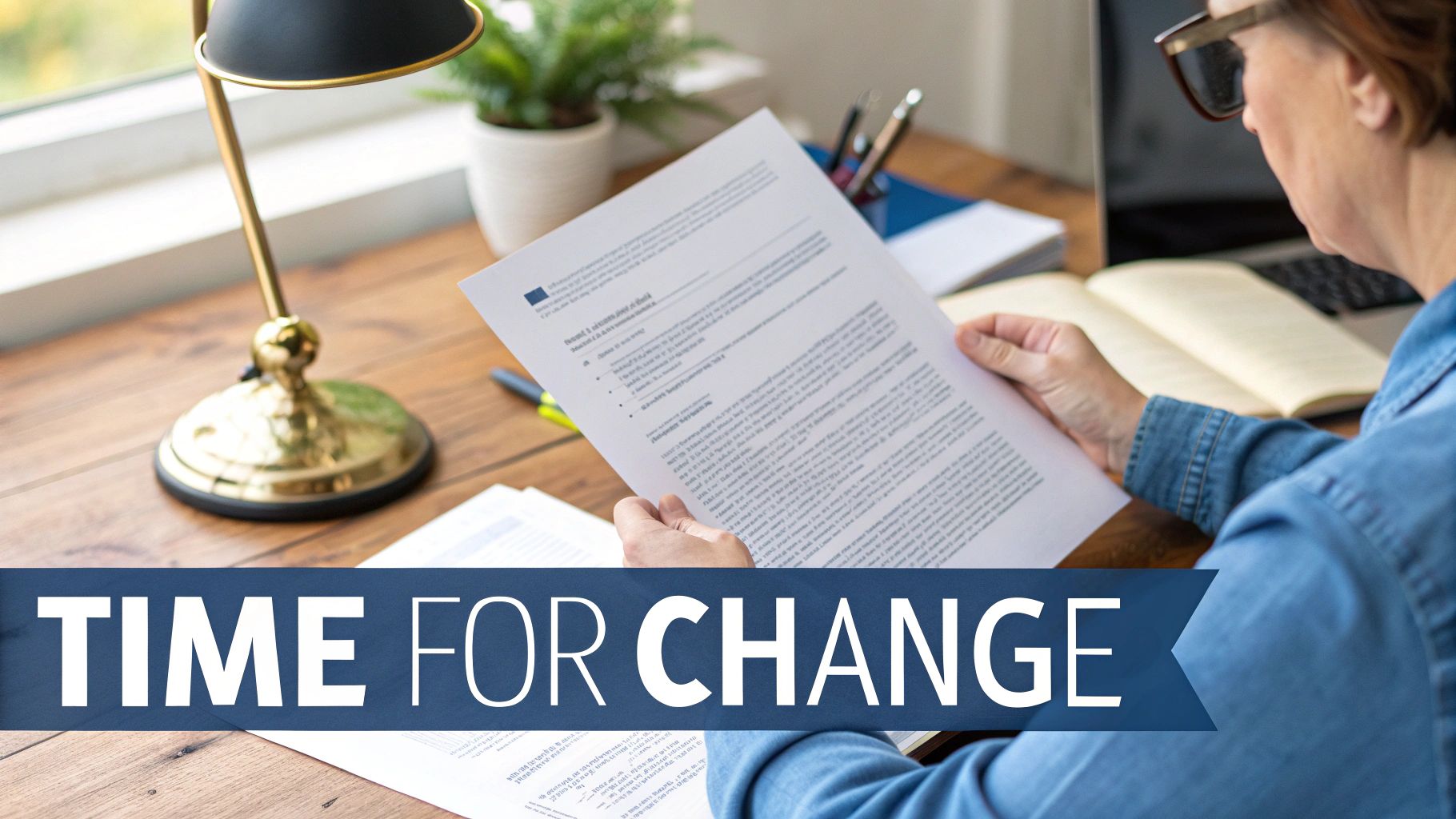 A person sitting at a desk and reviewing insurance documents on a laptop.