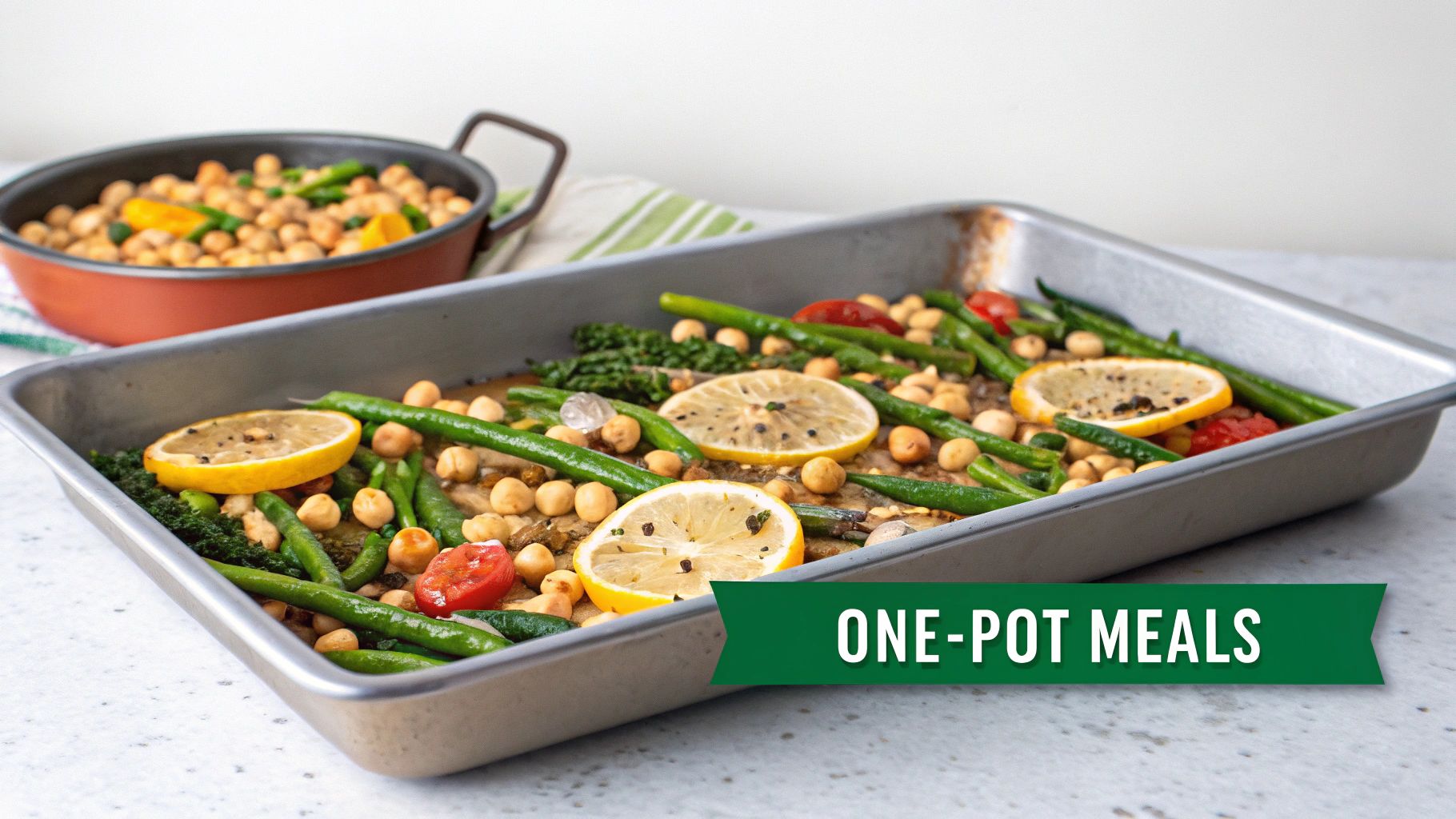 A large sheet pan meal featuring roasted chickpeas, green beans, tomatoes, and lemon slices.