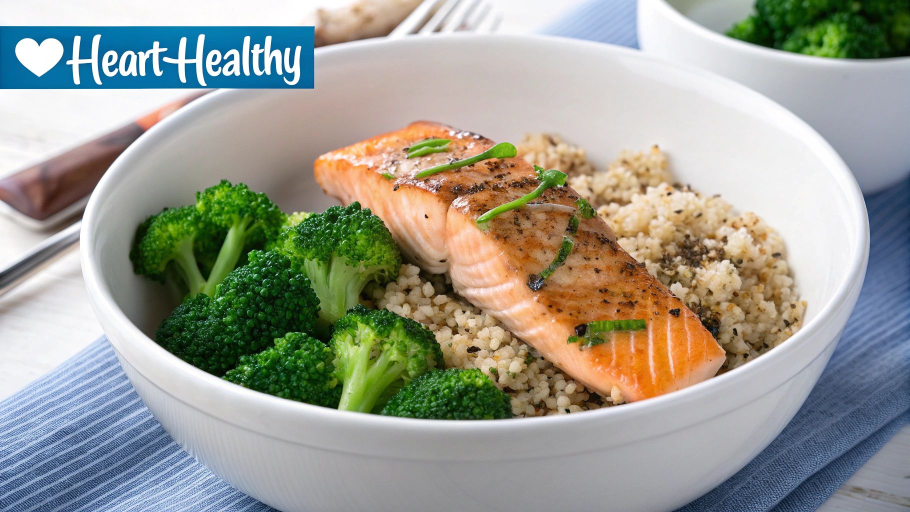 A heart-healthy meal with grilled salmon, steamed broccoli, and quinoa in a white bowl.