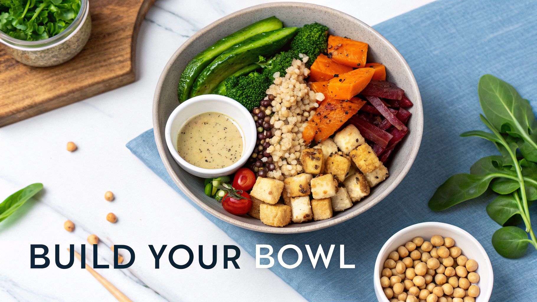 A vibrant, healthy grain bowl with roasted sweet potatoes, broccoli, tofu, and a side of dressing.