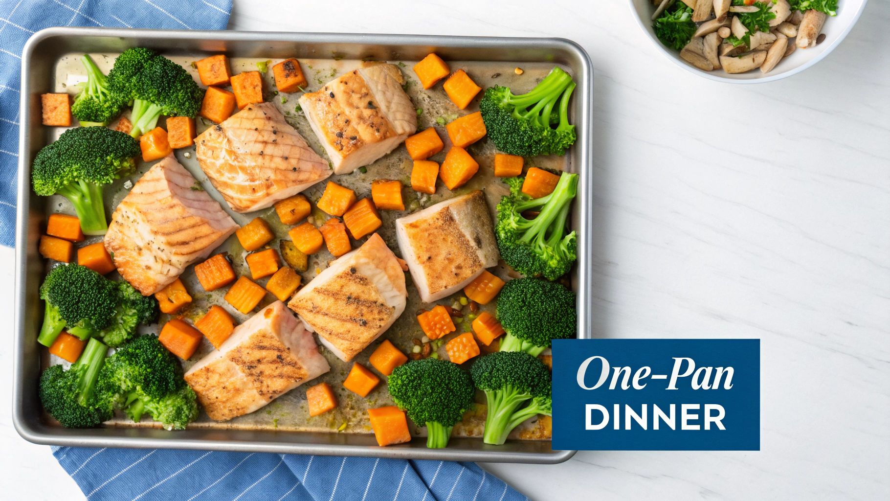 A sheet pan with baked salmon fillets, roasted broccoli florets, and diced sweet potatoes, a one-pan dinner.
