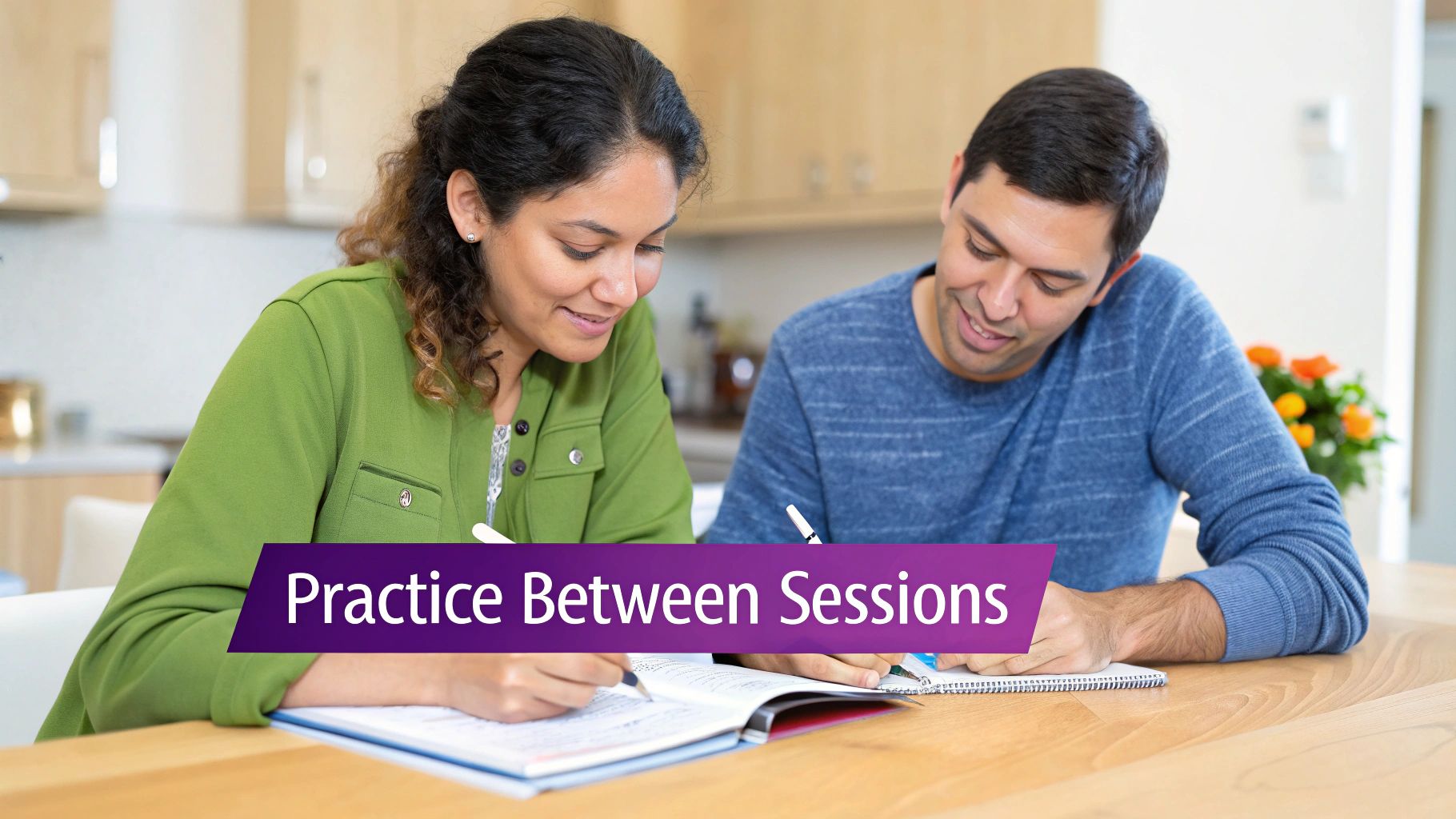 Two people, a man and a woman, smiling and writing in notebooks at a wooden table, practicing together.