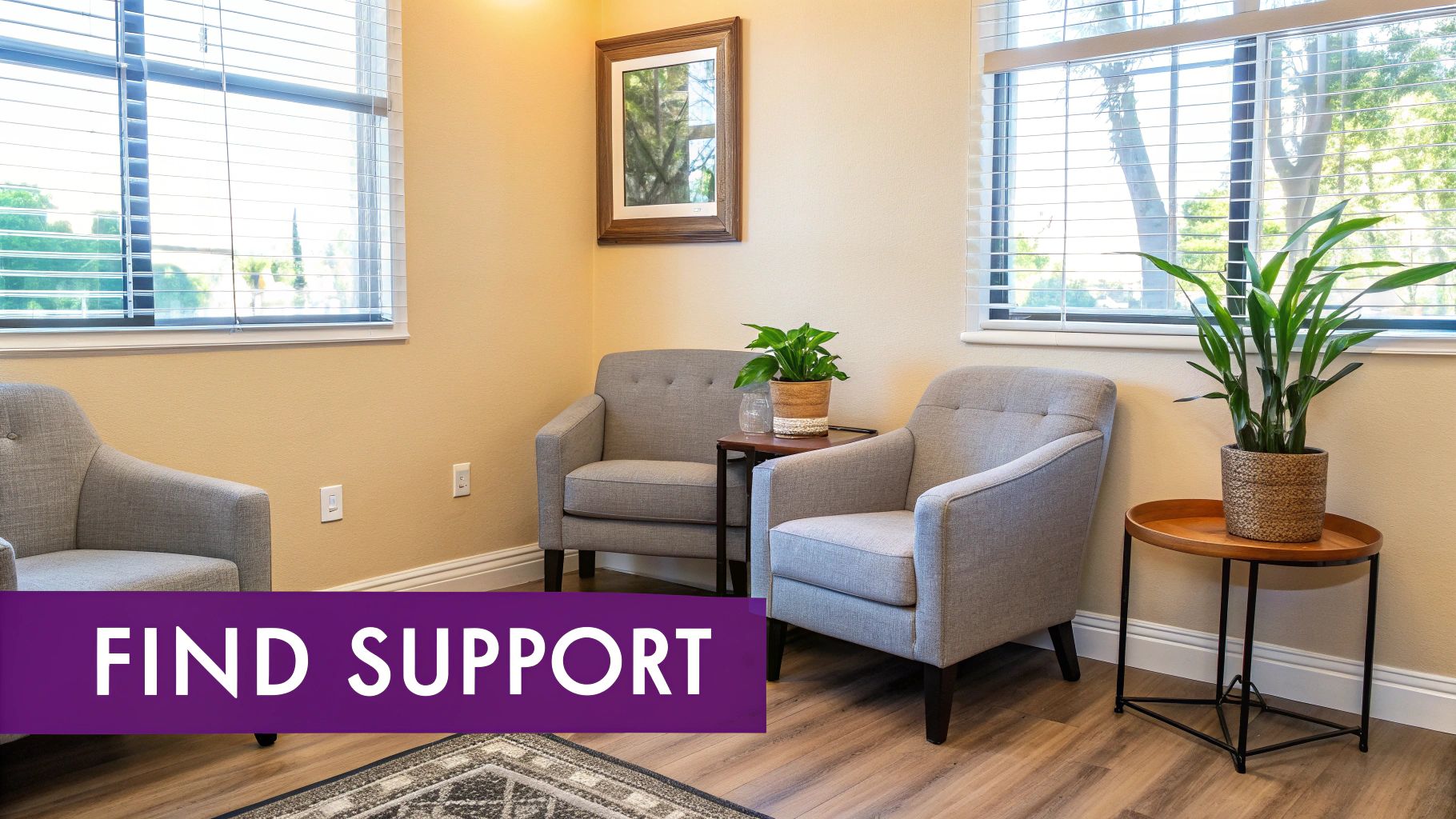 A peaceful waiting room with comfortable gray chairs, potted plants, and windows with blinds.