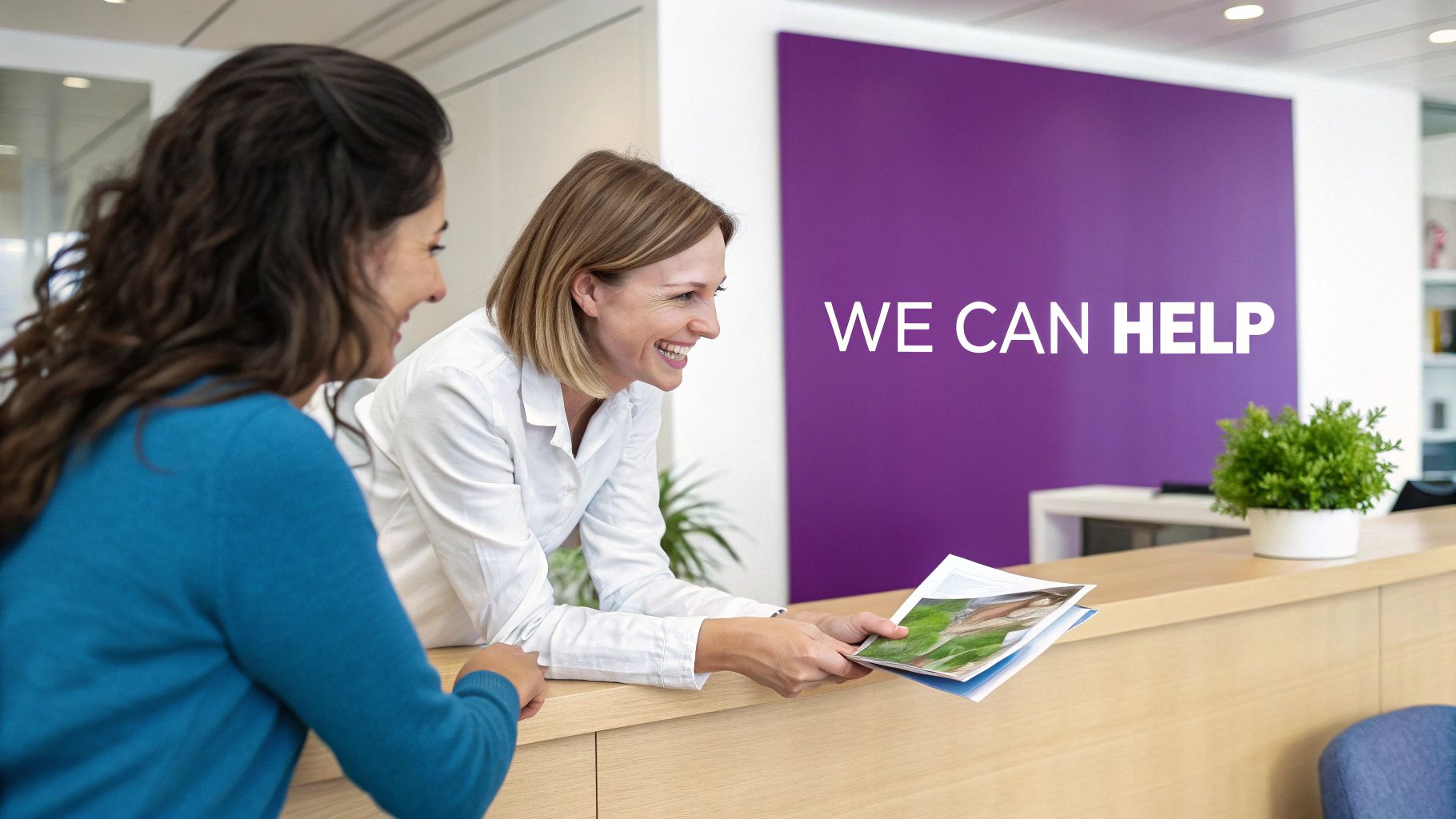 Two women smiling at a reception desk, one handing brochures to a client with 'WE CAN HELP' on the wall.