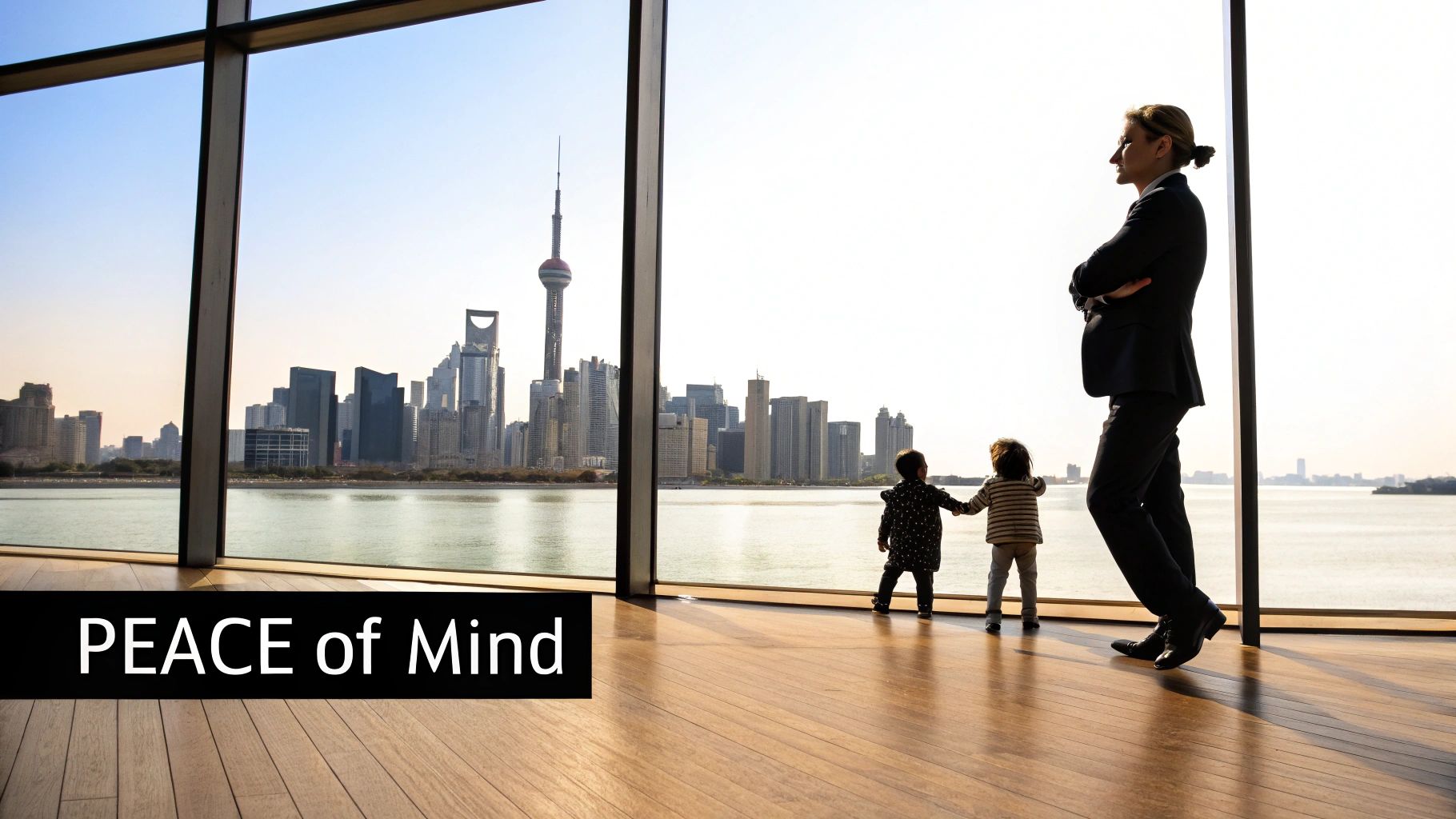 A businesswoman and two young children look out a large window at a modern city skyline and river.