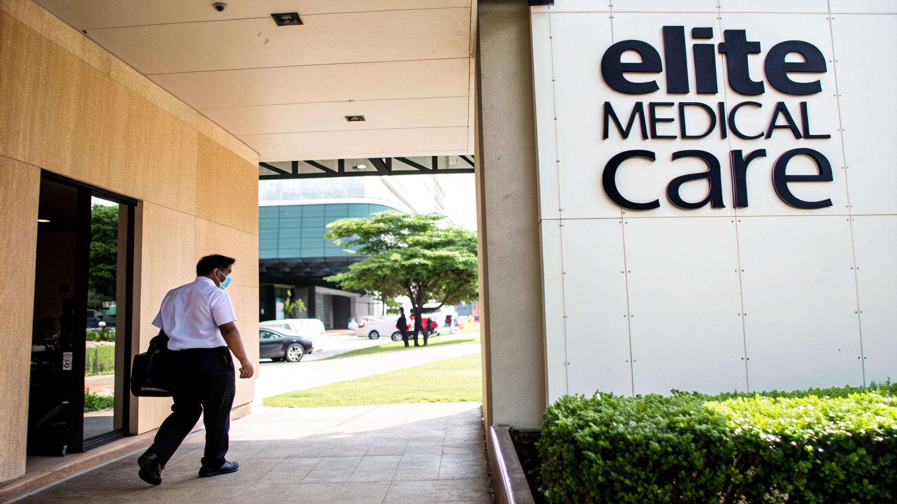 A man wearing a face mask walks past the entrance of an "Elite Medical Care" building.