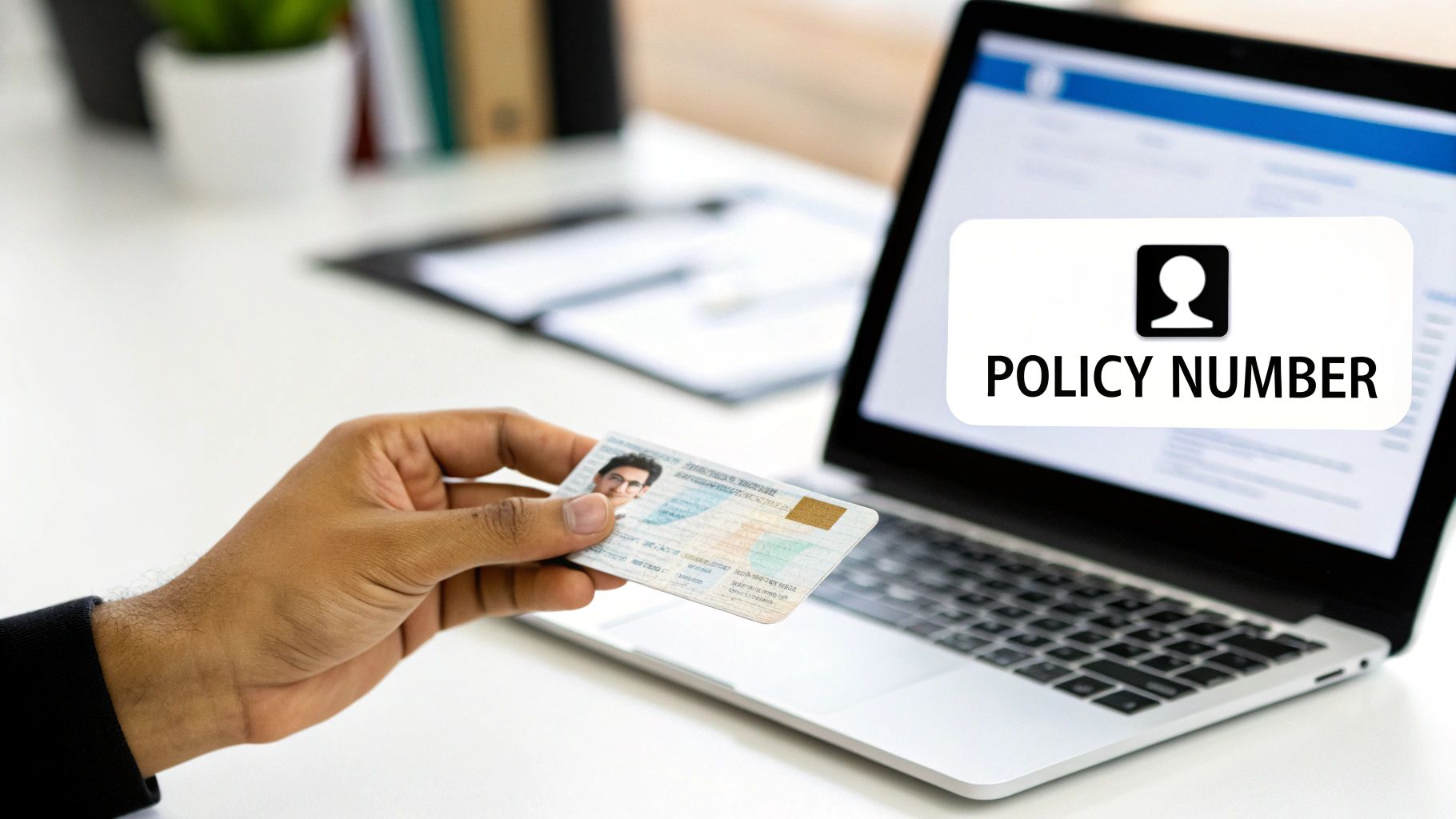 A hand holds a policy card in front of a laptop displaying a 'POLICY NUMBER' graphic.