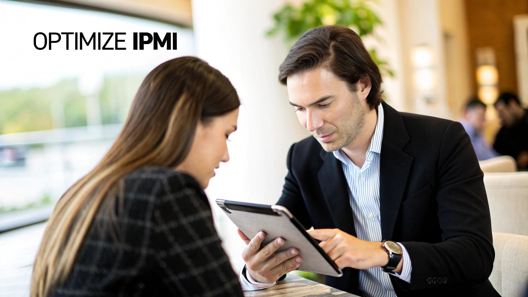 Two business professionals discussing information on a digital tablet in a bright, modern setting.