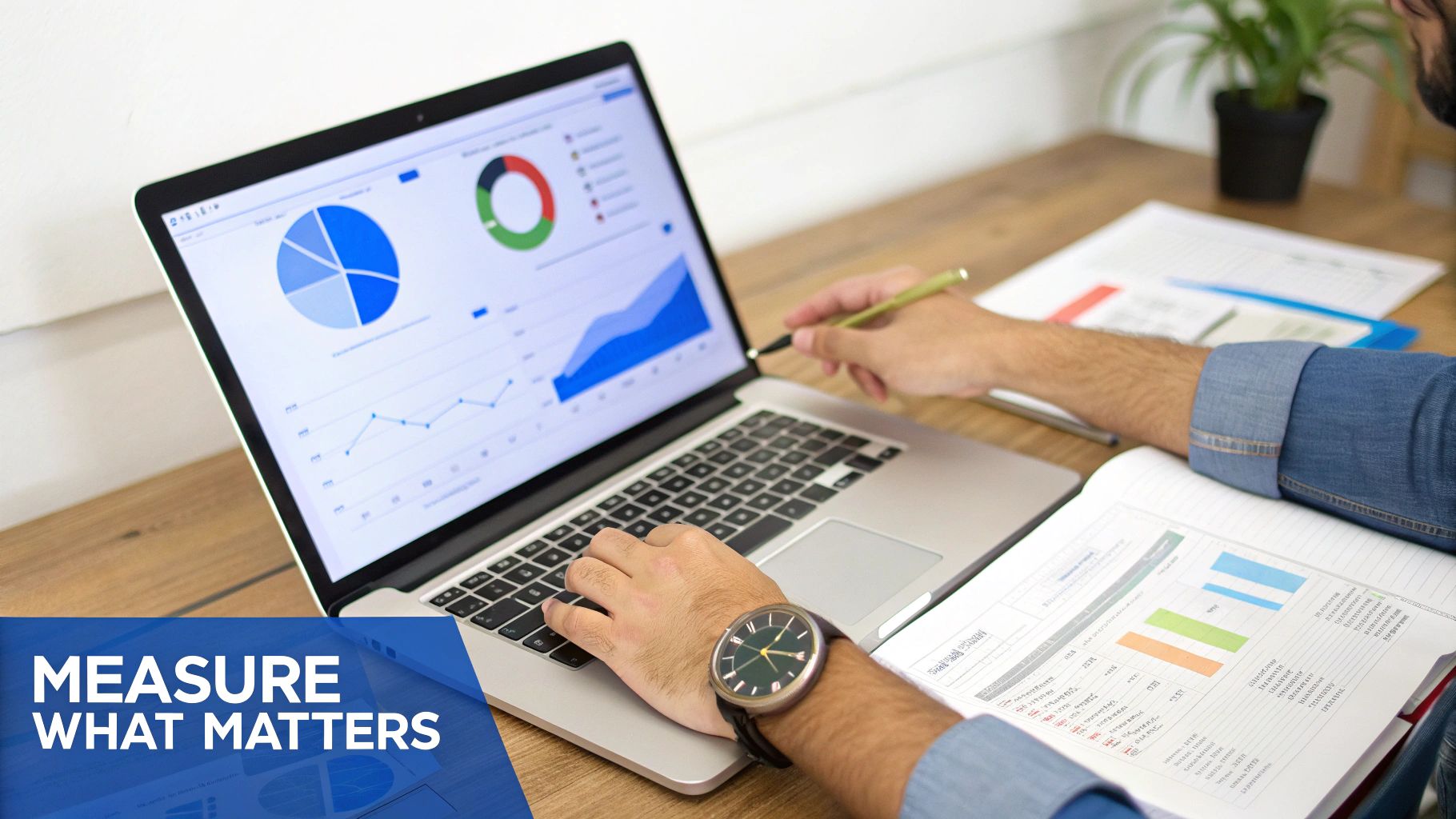 Business professional analyzing data charts and graphs on laptop while reviewing printed marketing reports