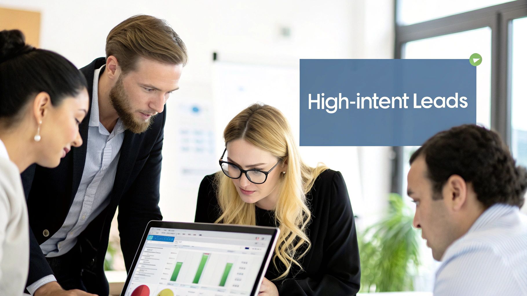 Four diverse business professionals analyzing high-intent leads data on a laptop in a modern office meeting.