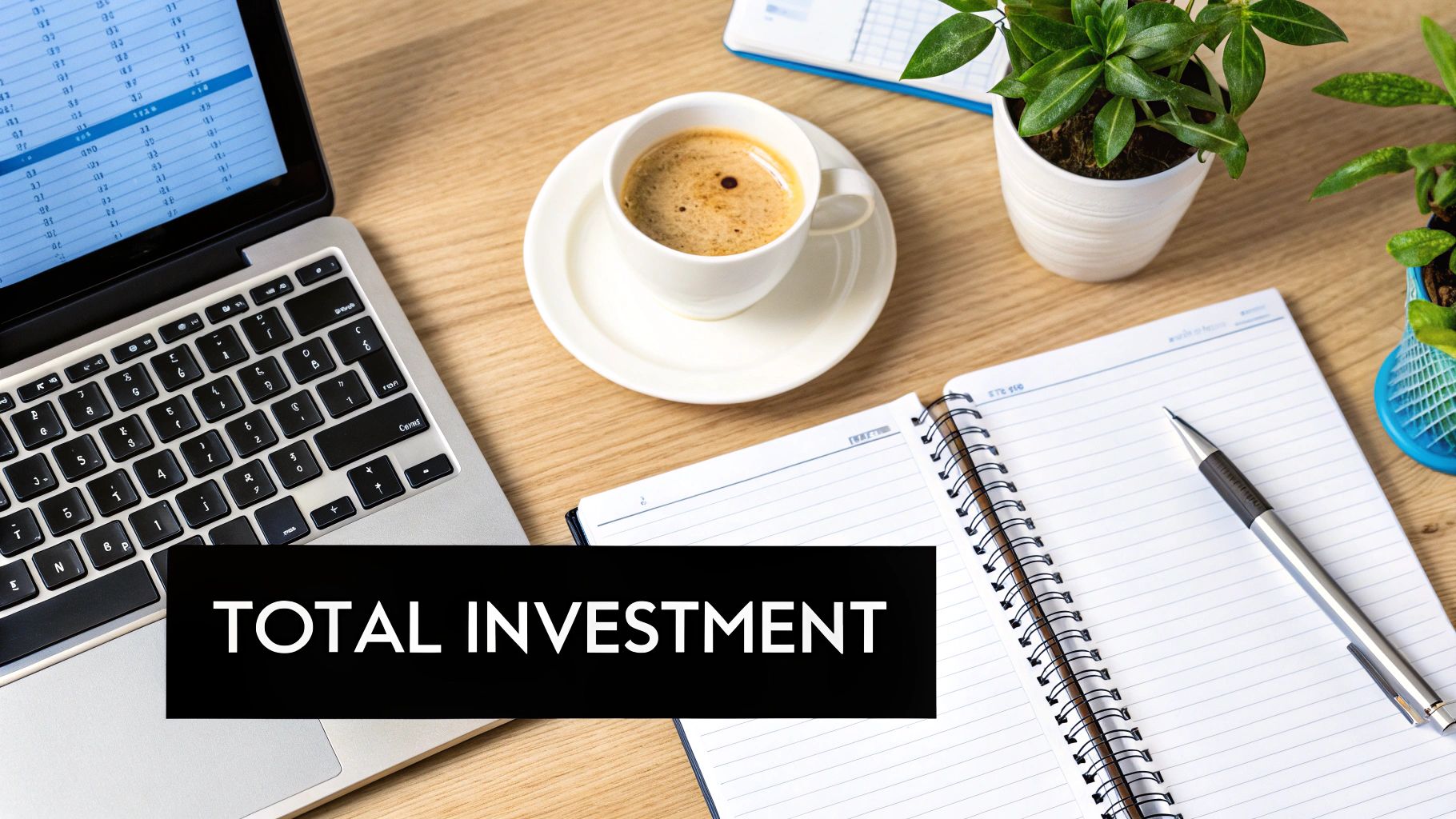 Flat lay of a business desk with a laptop displaying data, coffee, notebook, and 'TOTAL INVESTMENT' text.