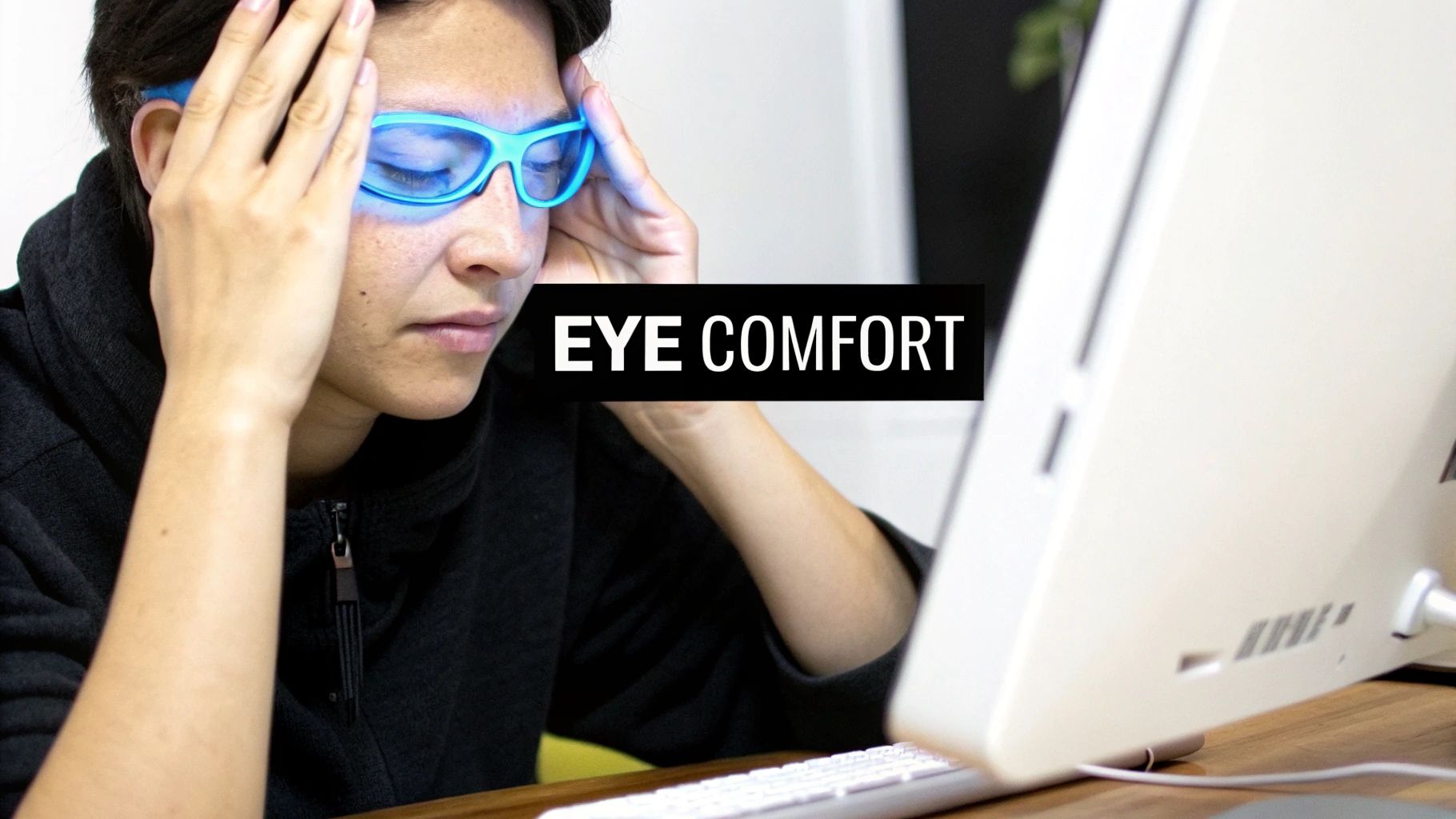 A person wearing Element Lux orange-lensed glasses while looking at their phone in bed.