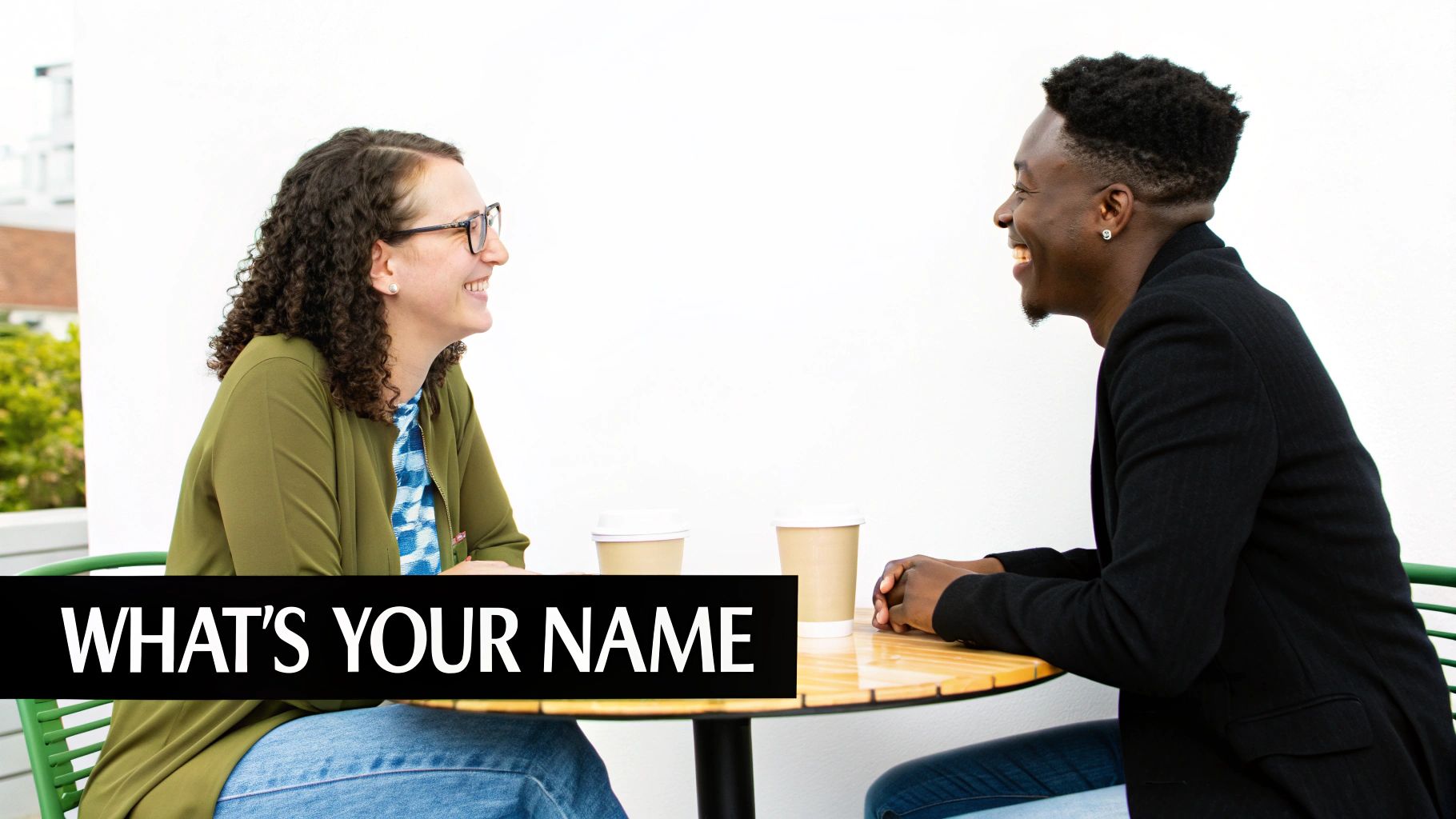 Two happy people, a woman and a man, share a coffee and conversation at a table.