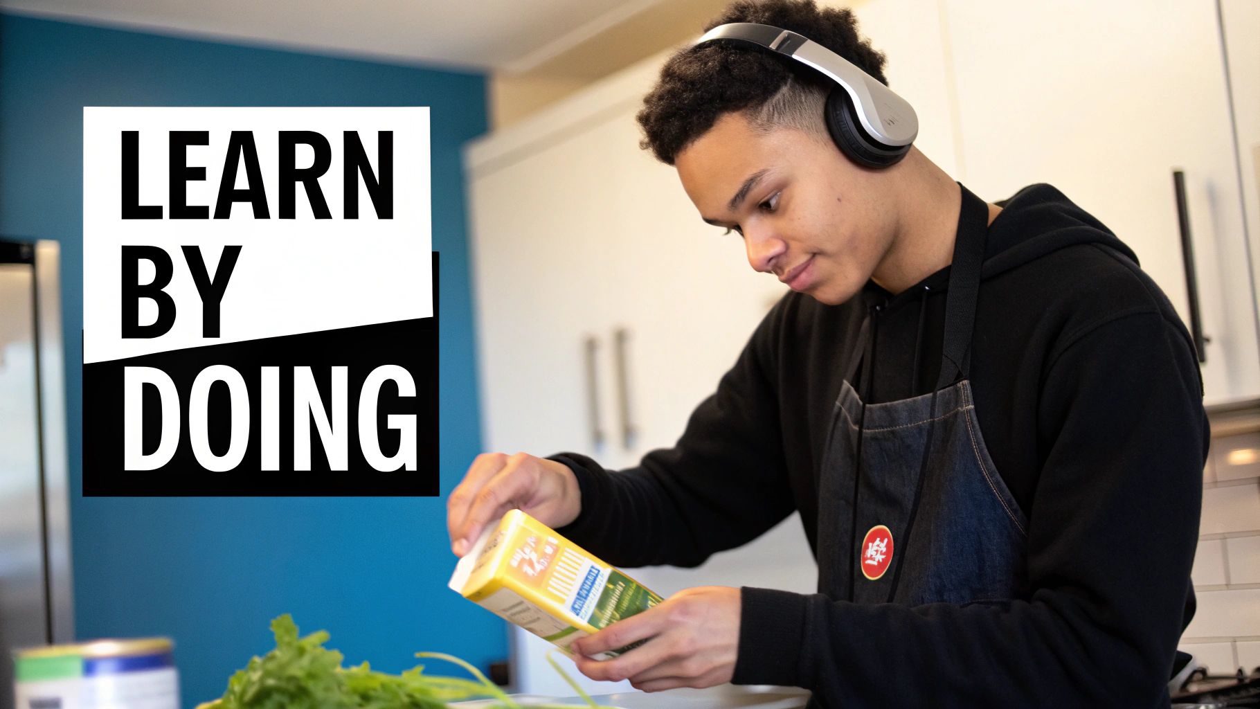 A young man with headphones and an apron opens a carton in a kitchen, with "LEARN BY DOING" text.