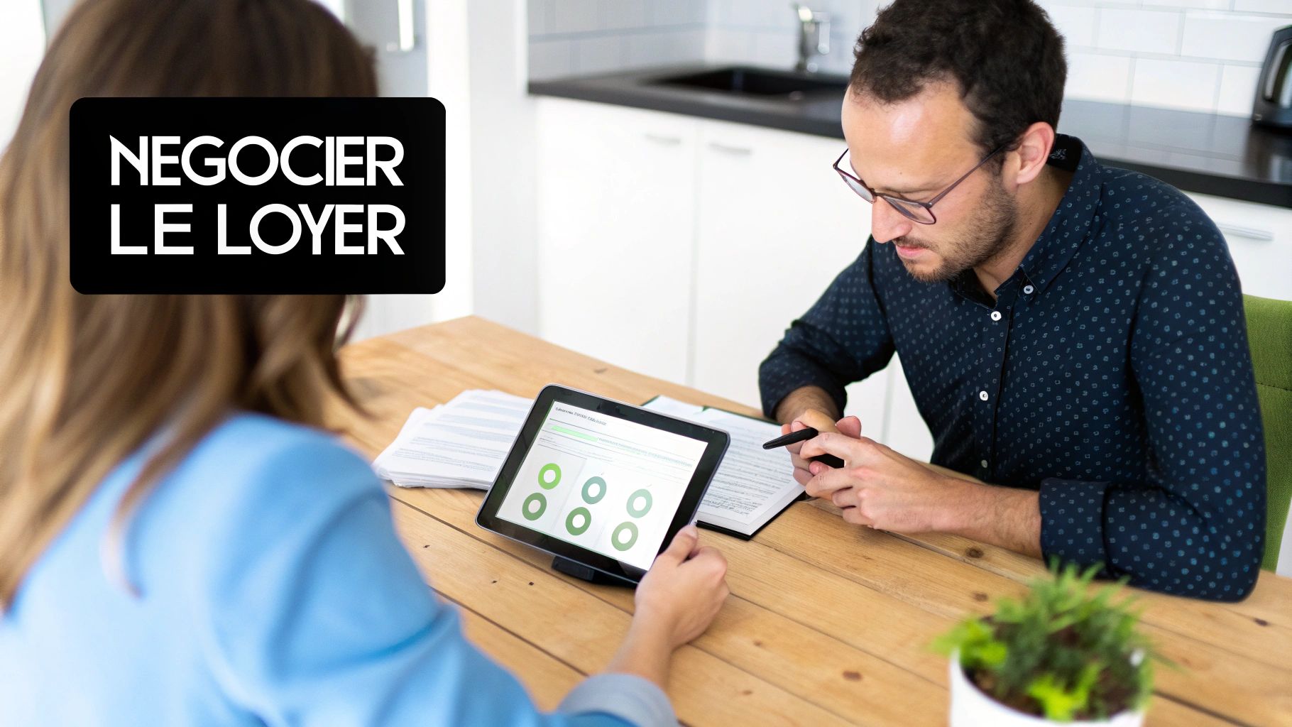 Deux personnes négocient un contrat de location autour d'une tablette numérique sur une table en bois