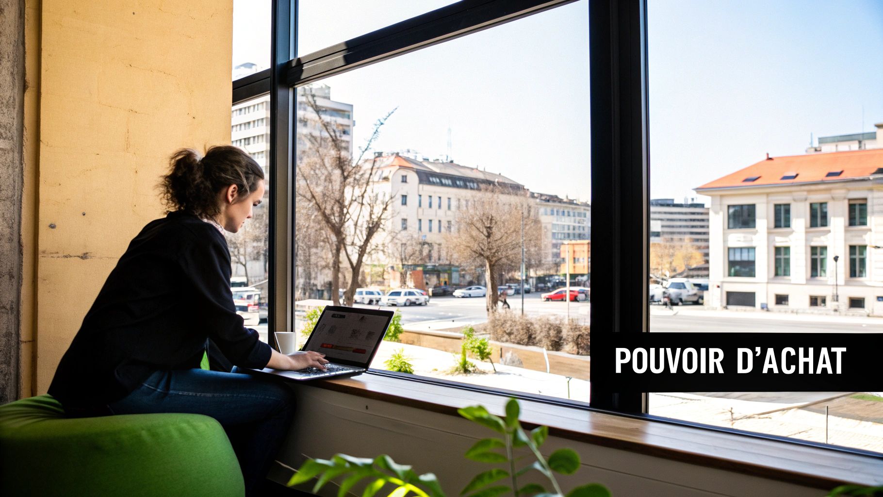 Une personne travaille sur un ordinateur portable près d'une fenêtre avec vue sur une ville animée. Le texte 'POUVOIR D'ACHAT' est visible.