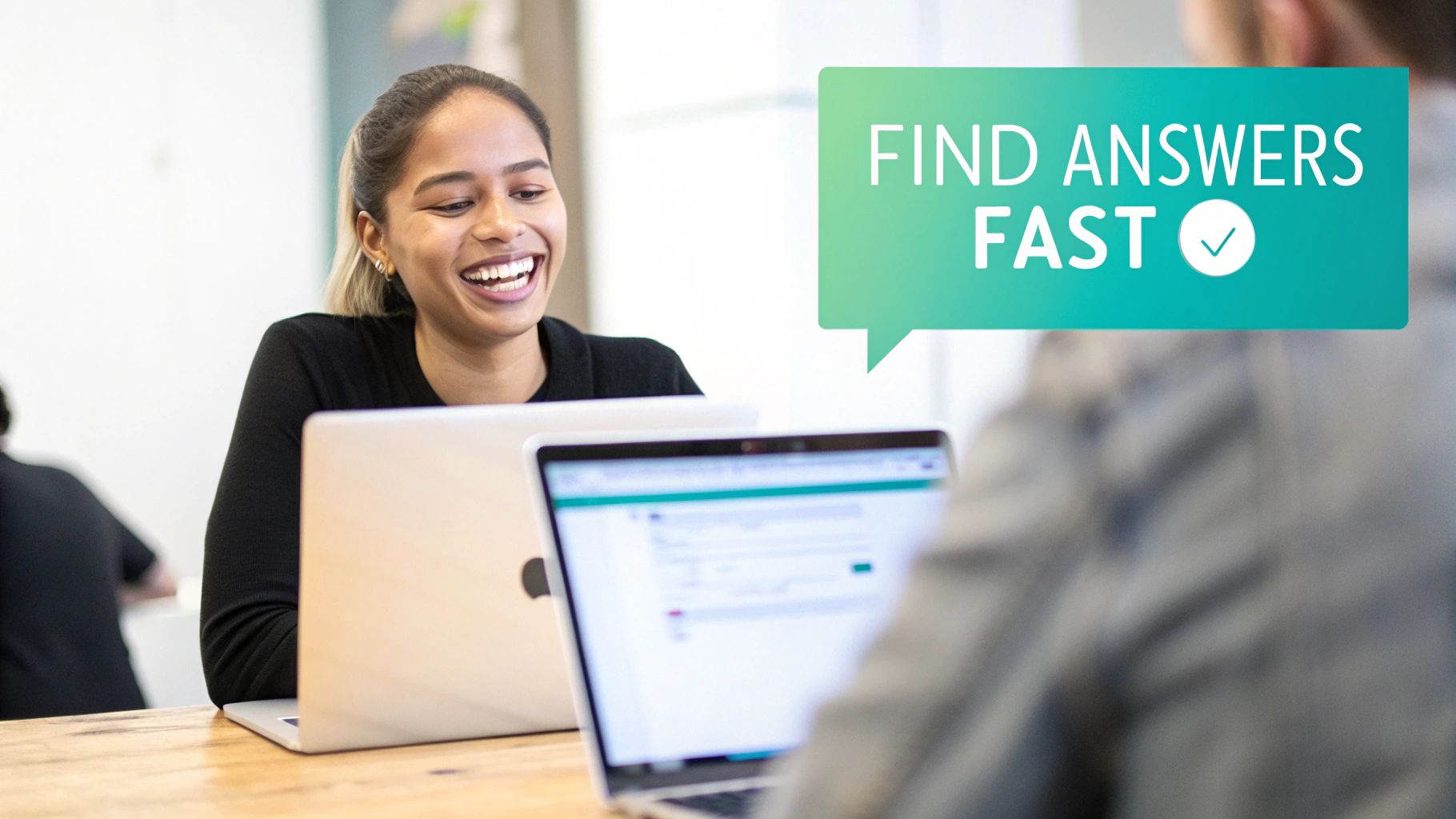 A smiling woman happily works on a laptop, with a speech bubble saying 'FIND ANSWERS FAST' in an office.