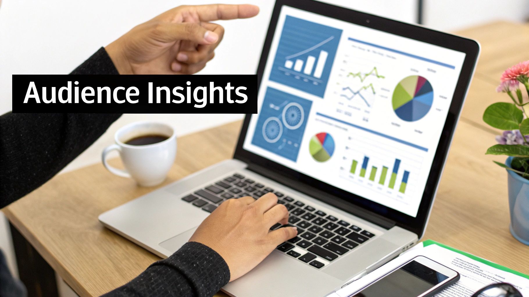 Two people analyze audience insights data on a laptop, showing charts and graphs, with one person pointing.