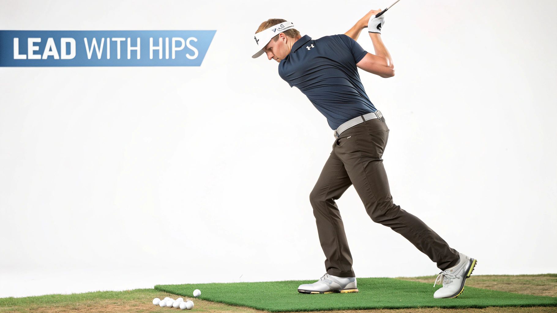 Golfer demonstrating the 'lead with hips' technique during a golf swing on a green mat.