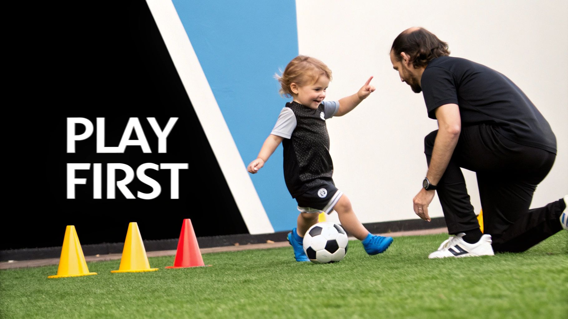 A happy toddler in a soccer jersey kicks a ball with an adult coach on artificial grass, near cones, with "PLAY FIRST" text.