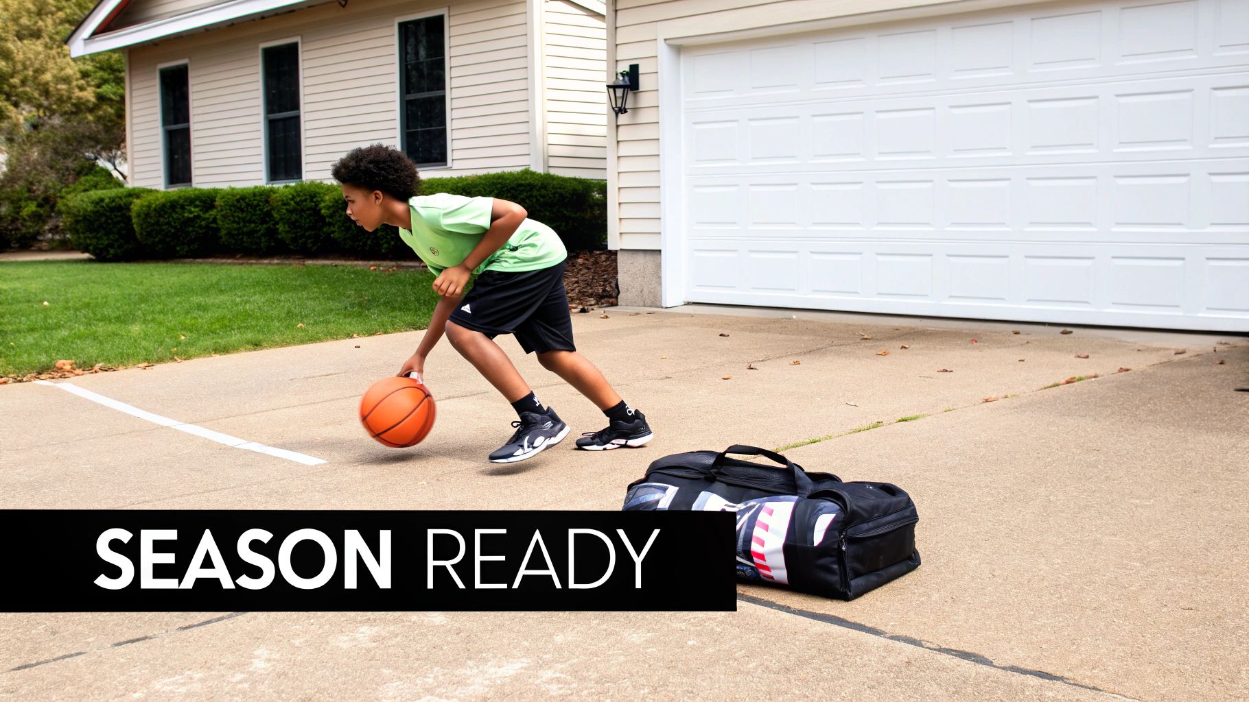 A young boy in a green shirt dribbles a basketball on a concrete driveway, practicing outdoors.