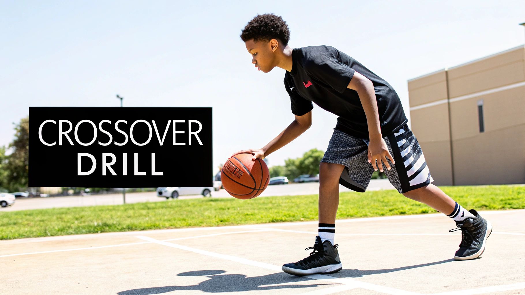 A young boy practices a basketball crossover drill on an outdoor court.