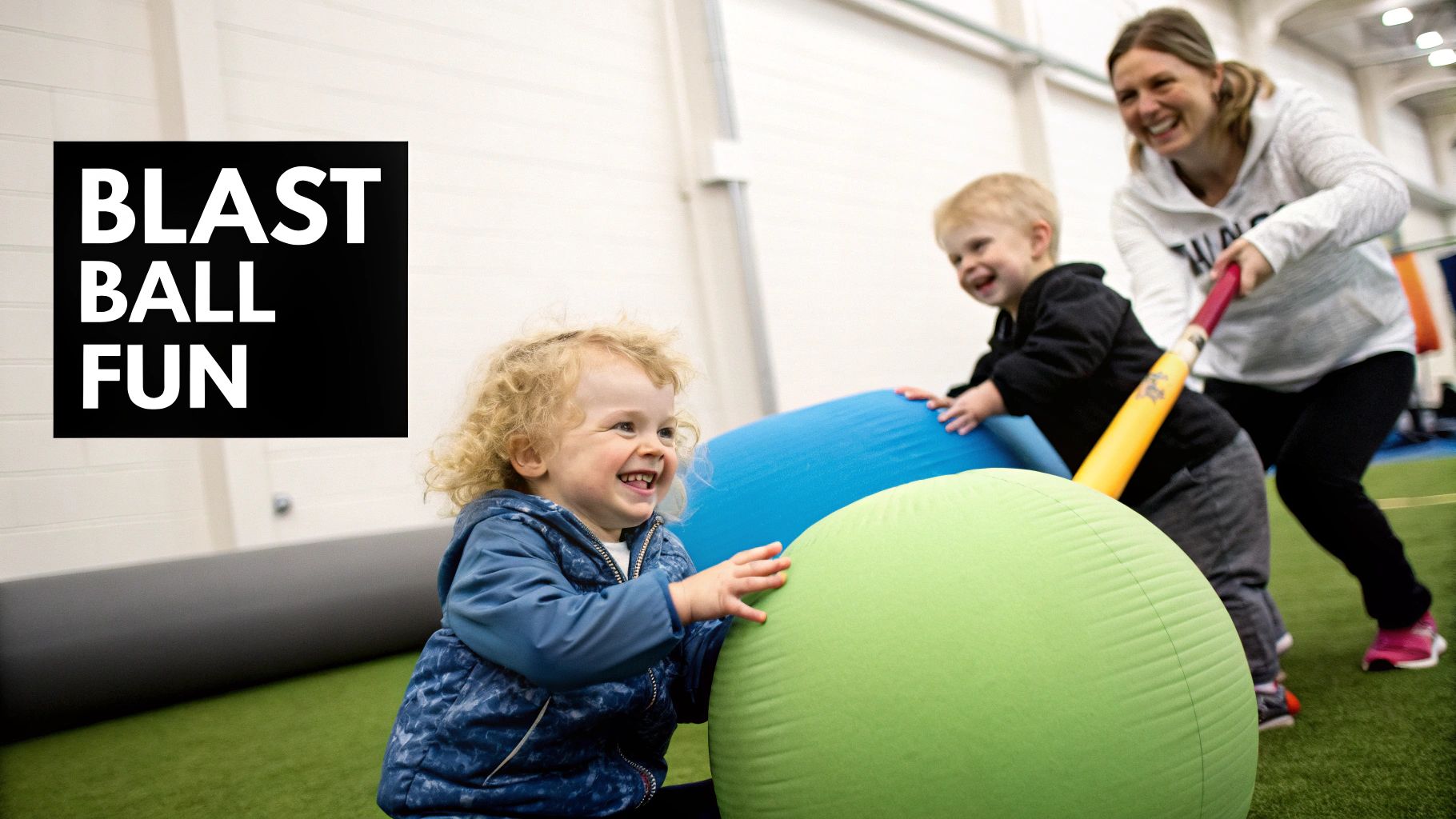 A woman and two young children joyfully play blast ball with colorful soft balls indoors.