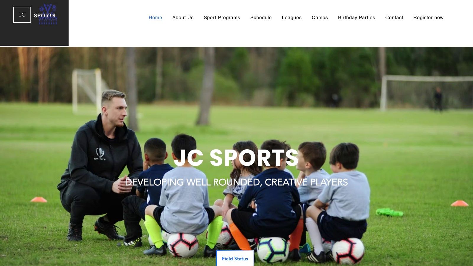 A young boy in a blue jersey smiles while dribbling a soccer ball during a youth sports camp at JC Sports Houston.
