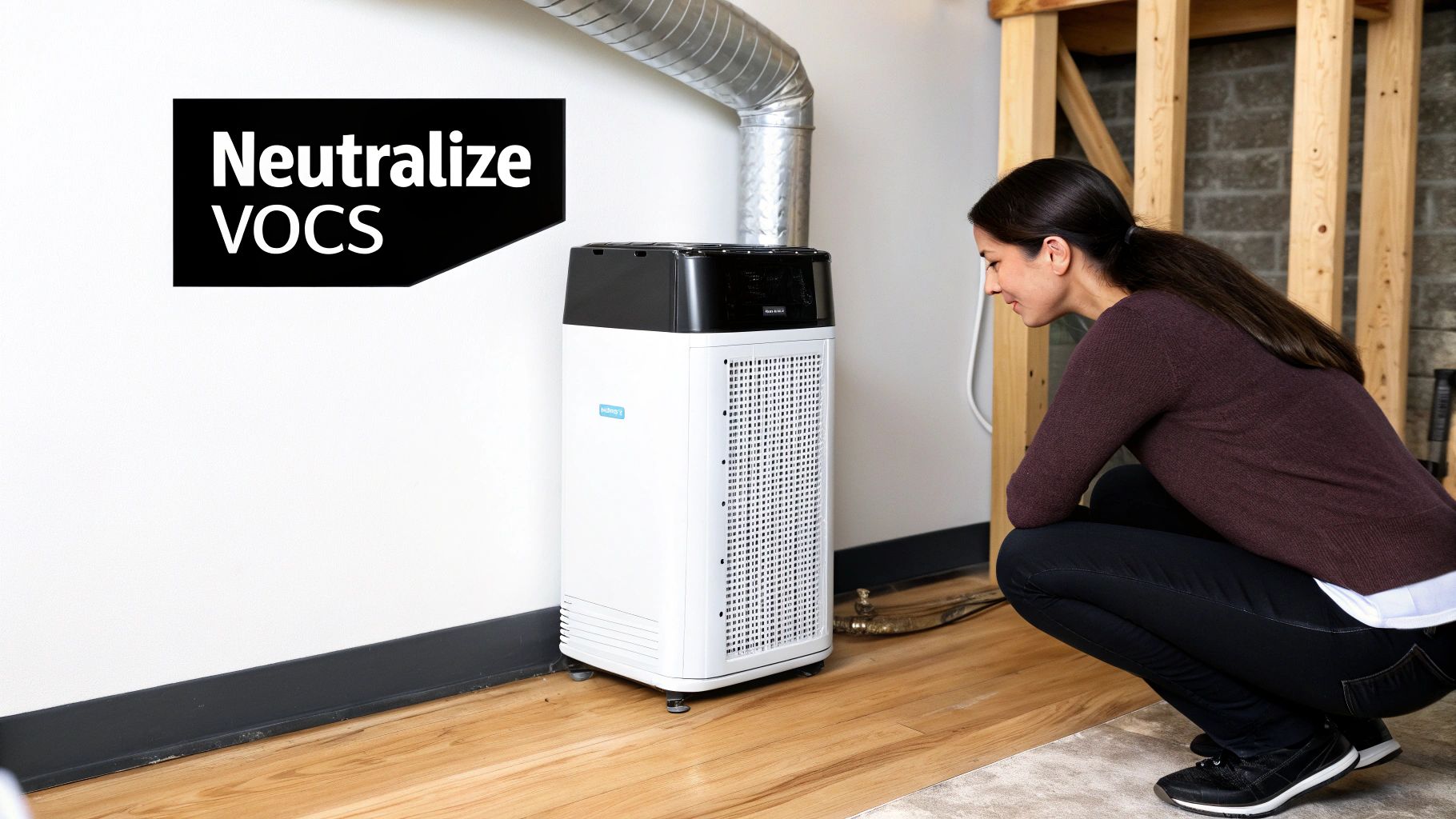 A woman squats, observing a white and black air purifier that neutralizes VOCs in a room.
