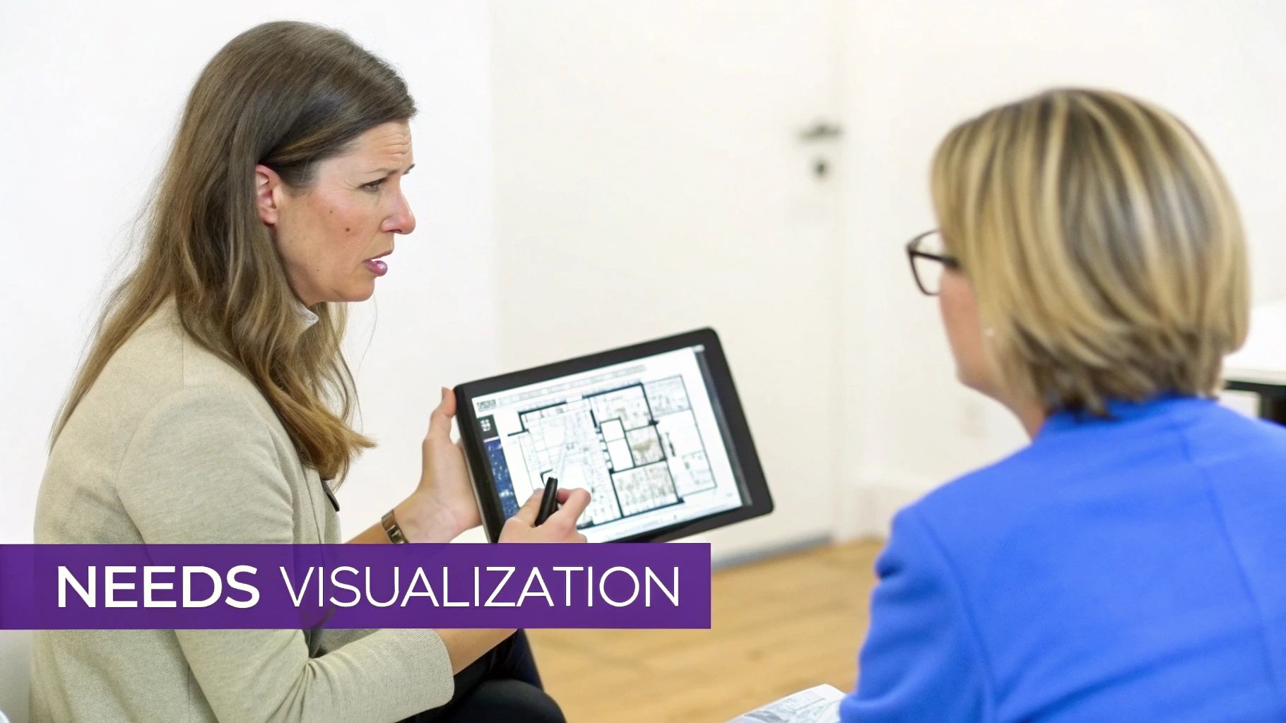 A woman points at a digital floor plan on a tablet while discussing interior design with another person.