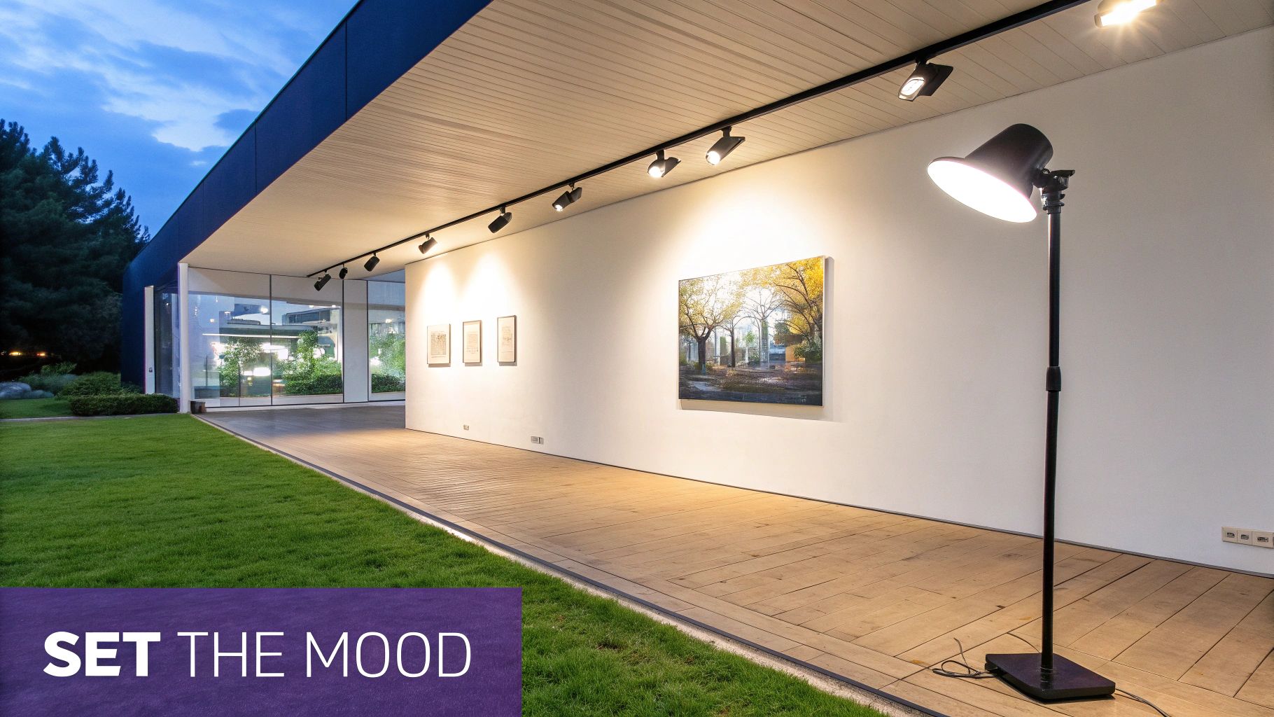 Modern exterior gallery walkway with wooden floor, track lighting, an art display, and a stylish floor lamp.
