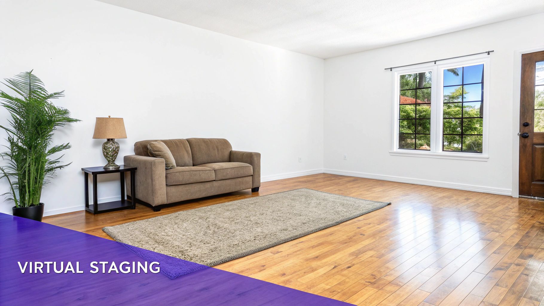 A virtually staged empty living room with a brown couch, plant, rug, and wooden floor.