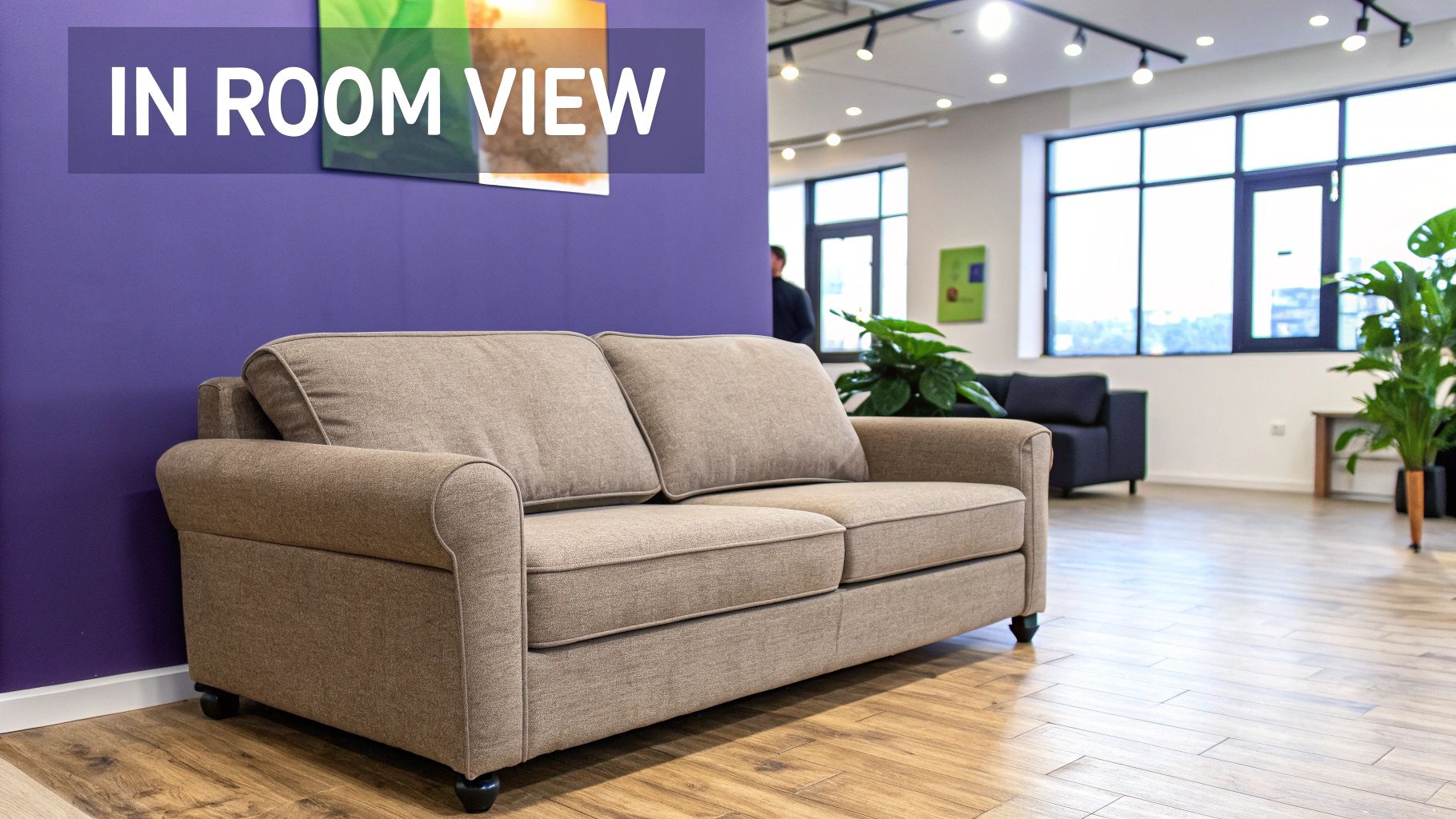 A beige two-seater sofa sits against a purple wall in a modern office or lounge area.