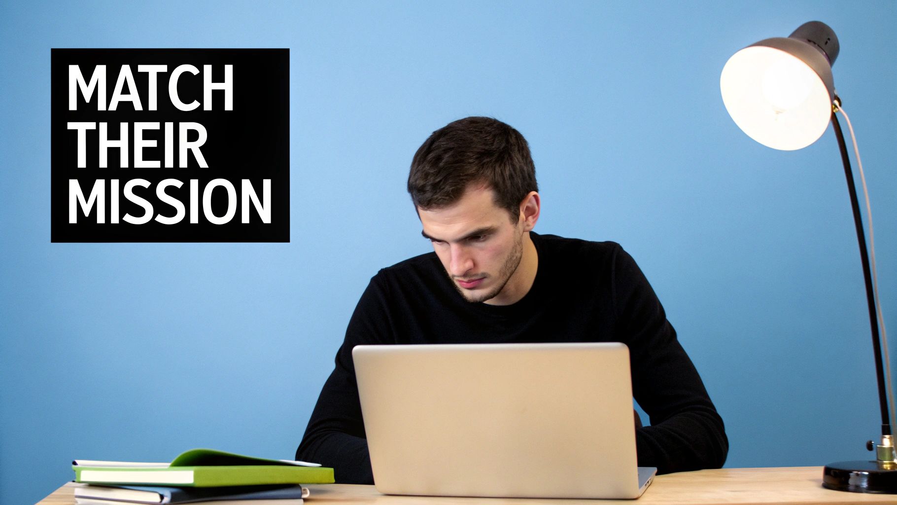 A man sits at a wooden desk, focused on a laptop, with books and a lamp. Text reads 'MATCH THEIR MISSION'.