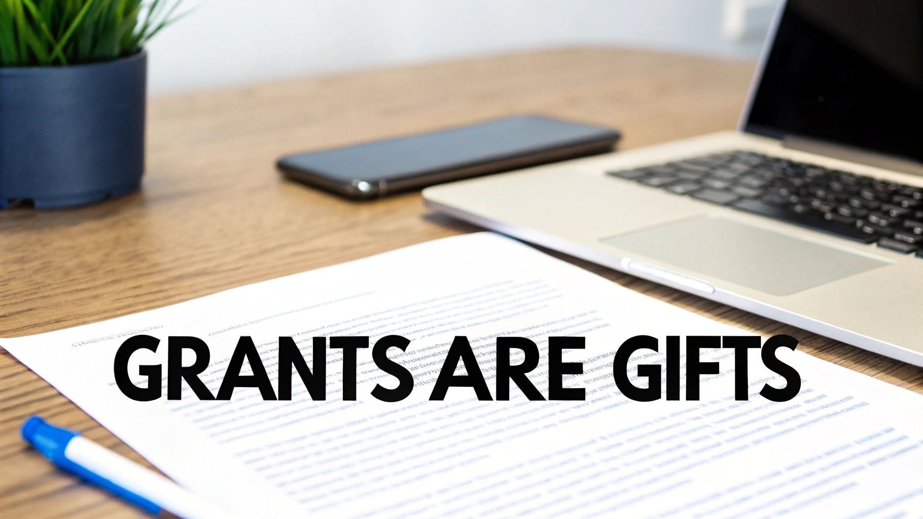 A document on a desk with the bold text 'GRANTS ARE GIFTS', alongside a laptop, phone, and plant.