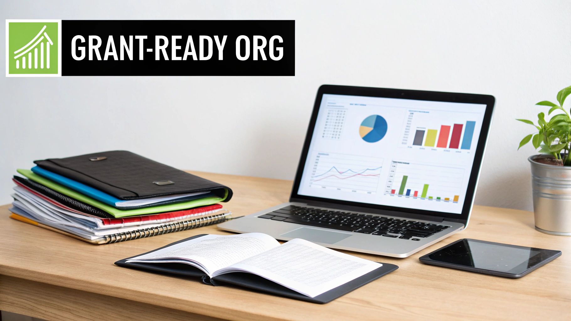 A desk with a laptop displaying charts, folders, and books, representing grant readiness for organizations.