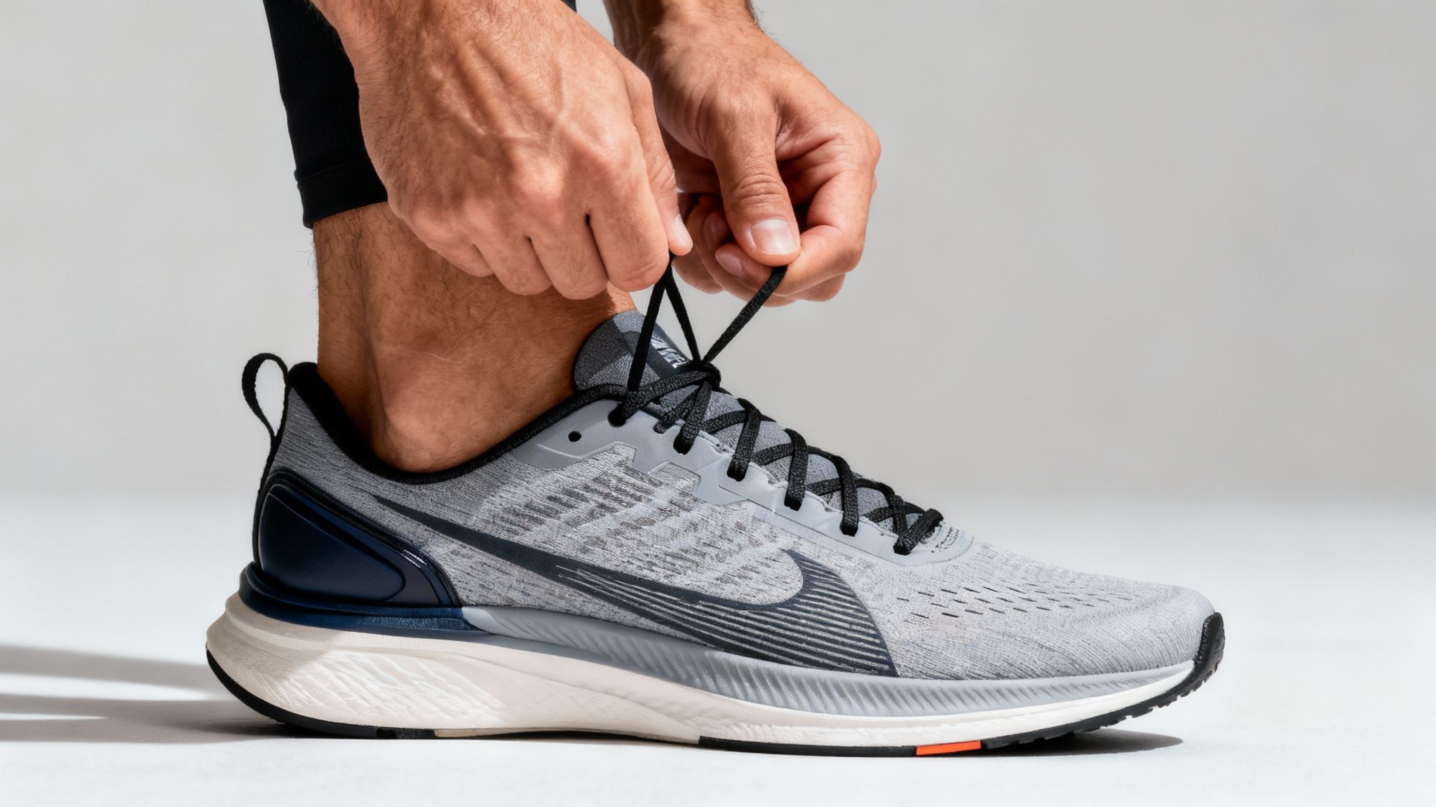 A man tying his running shoes before heading out for a run.