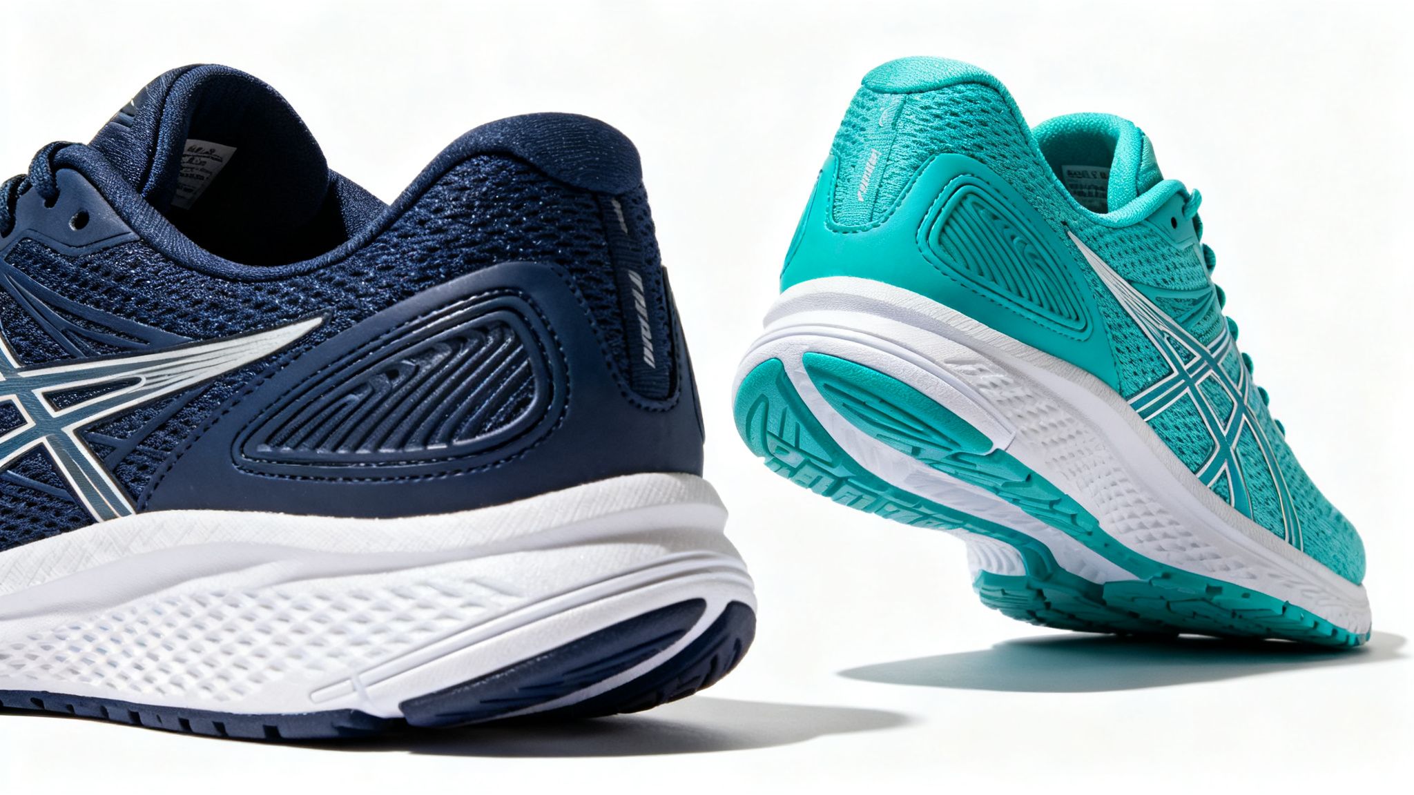 Two athletic running shoes, one navy blue and one teal, showcasing their design and soles.