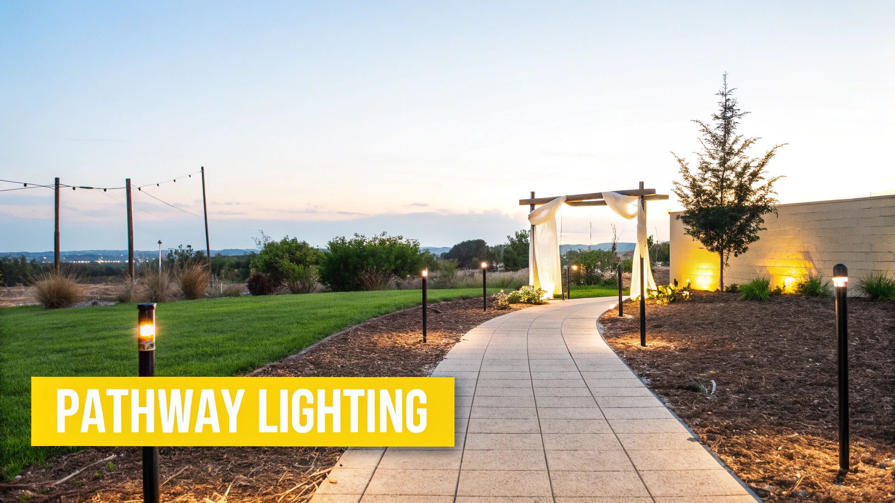 10 Breathtaking Outdoor Wedding Lighting Ideas for Your Knoxville Nuptials A beautifully lit outdoor pathway at dusk, with modern bollard lights, leading to a draped archway.
