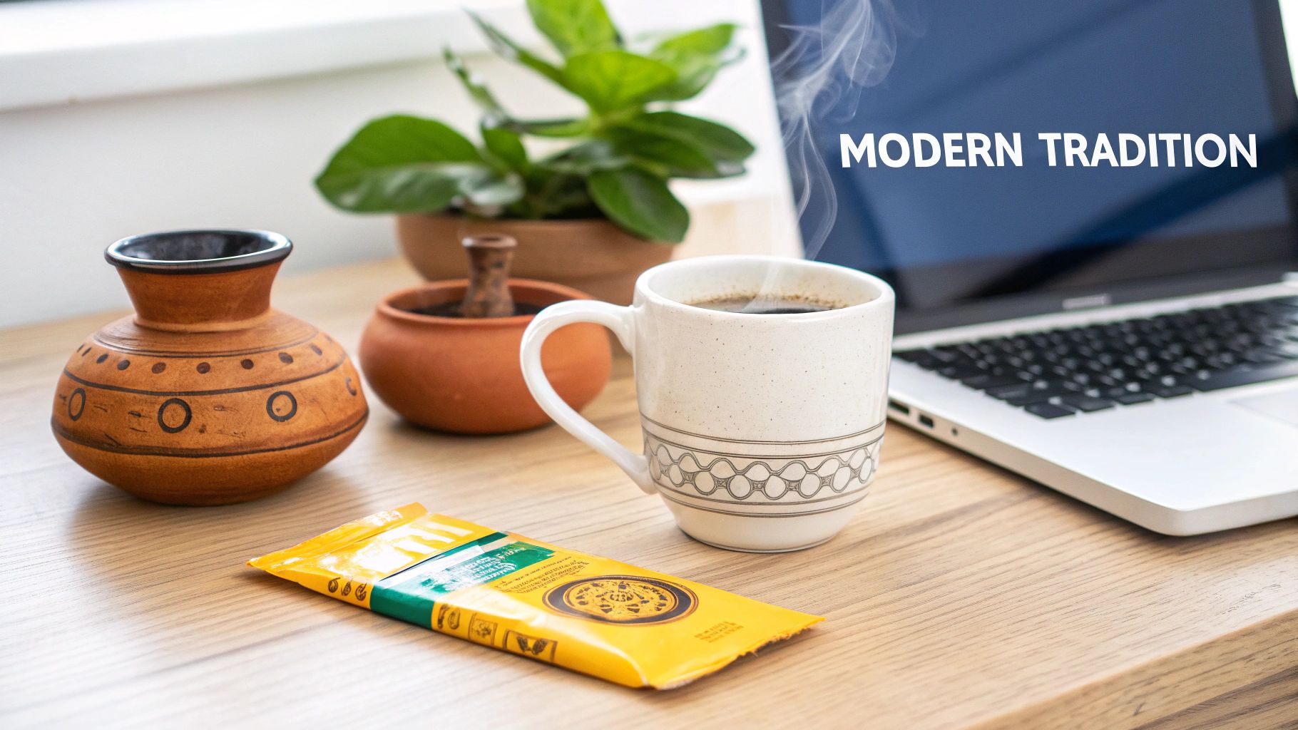 Steaming coffee mug next to instant coffee packet, laptop, and traditional pottery on wooden desk