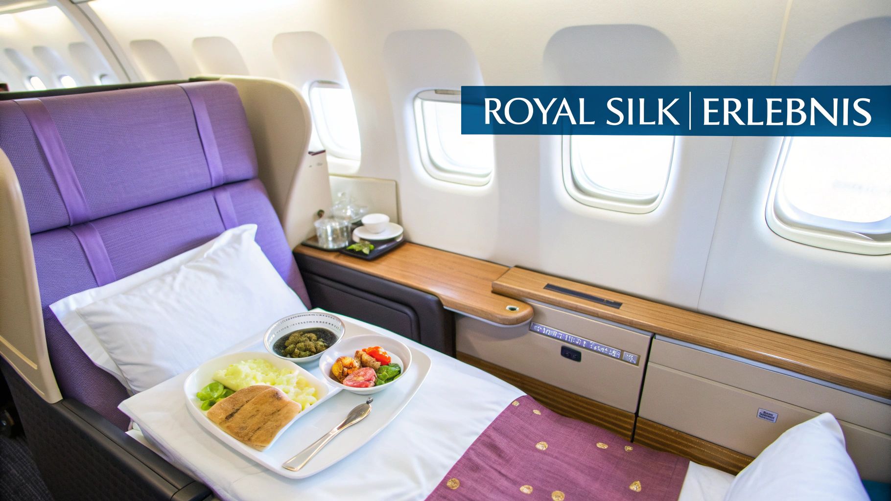 Ein luxuriöser Flugzeugsitz in der Royal Silk Klasse mit einem servierten Menü und bequemen Kissen.