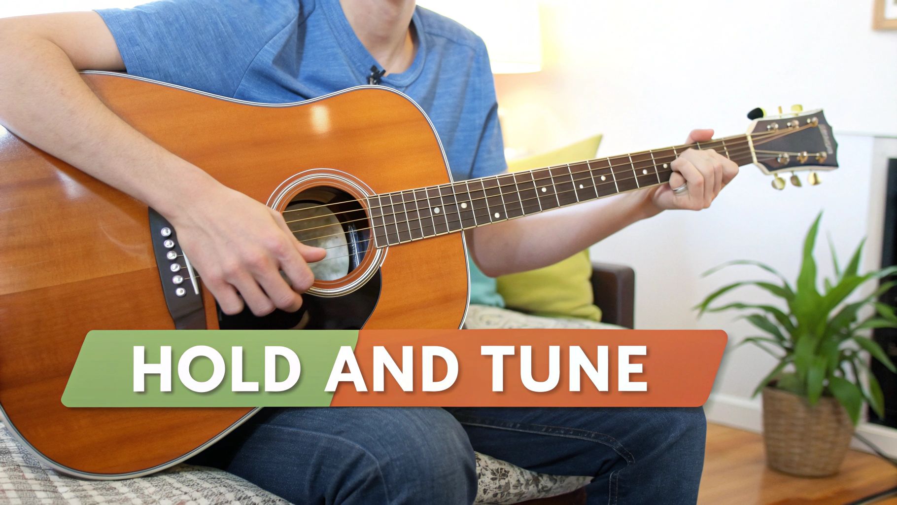 A person in a blue shirt demonstrates holding and strumming an acoustic guitar, with 'HOLD AND TUNE' text.