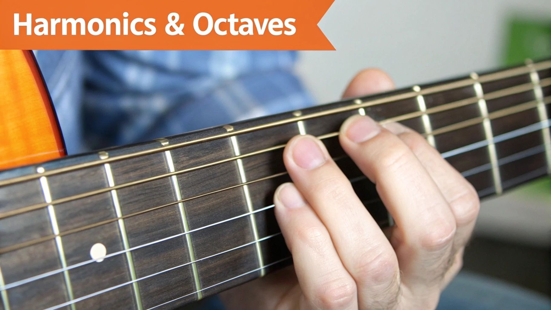 A musician's hand pressing strings on an acoustic guitar fretboard, for harmonics and octaves.